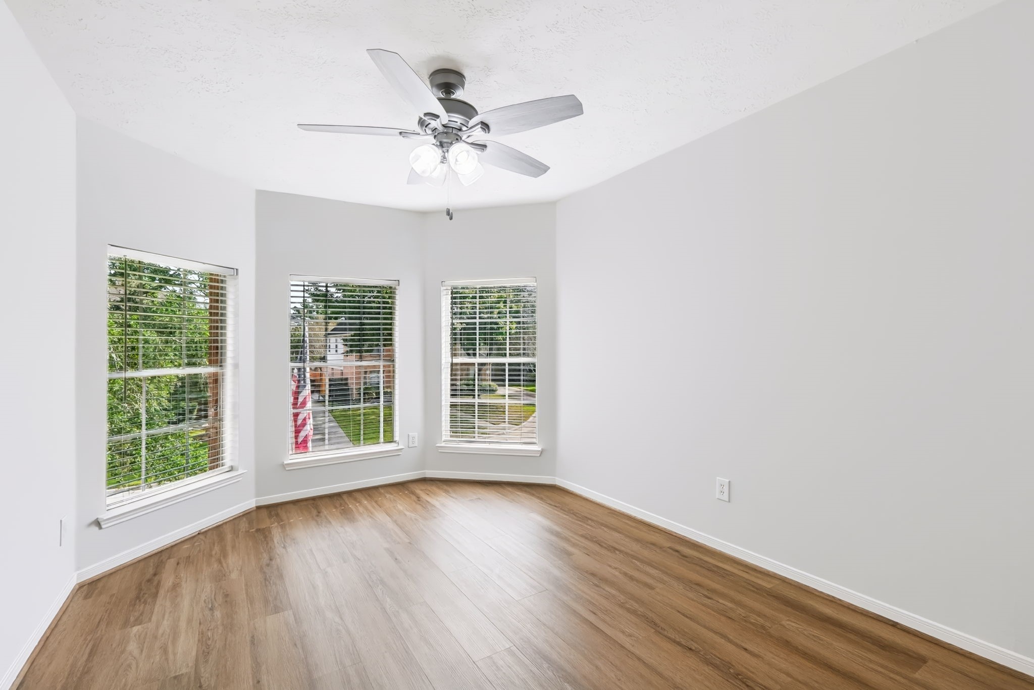 A charming window nook makes this bedroom feel extra special! Three windows bring in wonderful natural light, creating an inviting space for relaxing, reading or simply enjoying a little quiet time.