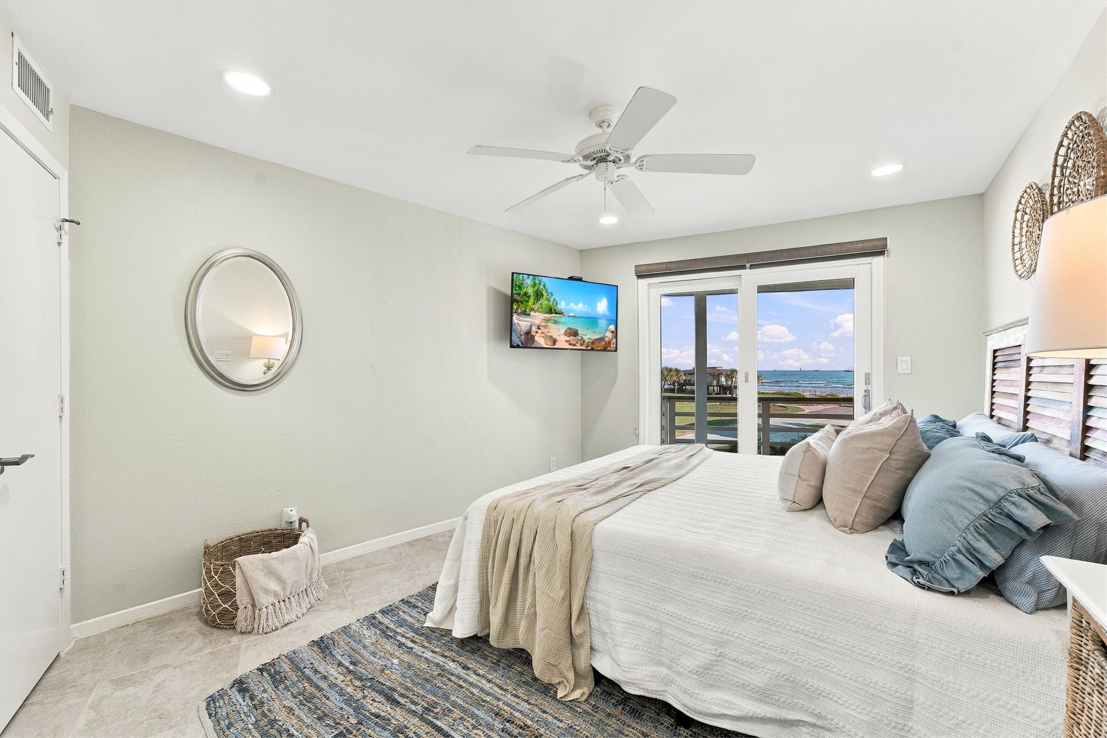 This inviting bedroom offers soothing coastal colors and direct balcony access, making morning coffee with a beach view an everyday pleasure.