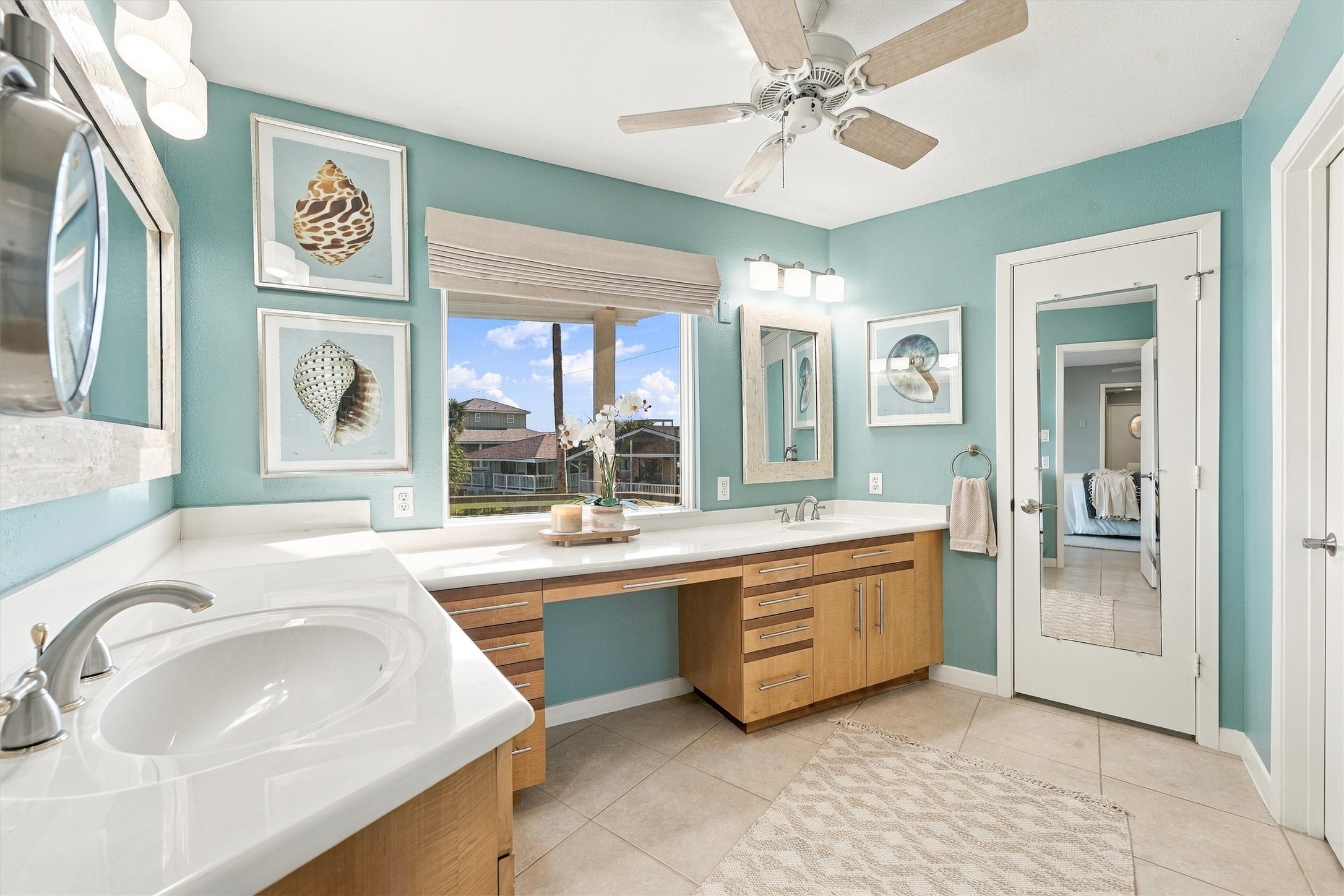A refreshing retreat of seafoam walls, crisp white counters, and warm wood cabinetry. Expansive vanities give everyone room to get ready for an evening out.