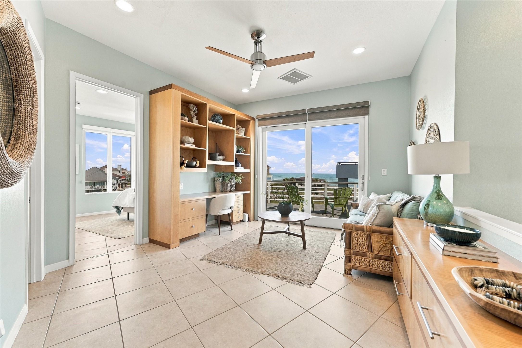 A little work, a little daydreaming, and a beautiful beach view. This bright study pairs a built-in desk and shelving with a comfortable sitting area, while sliding glass doors lead outside for a refreshing balcony break.