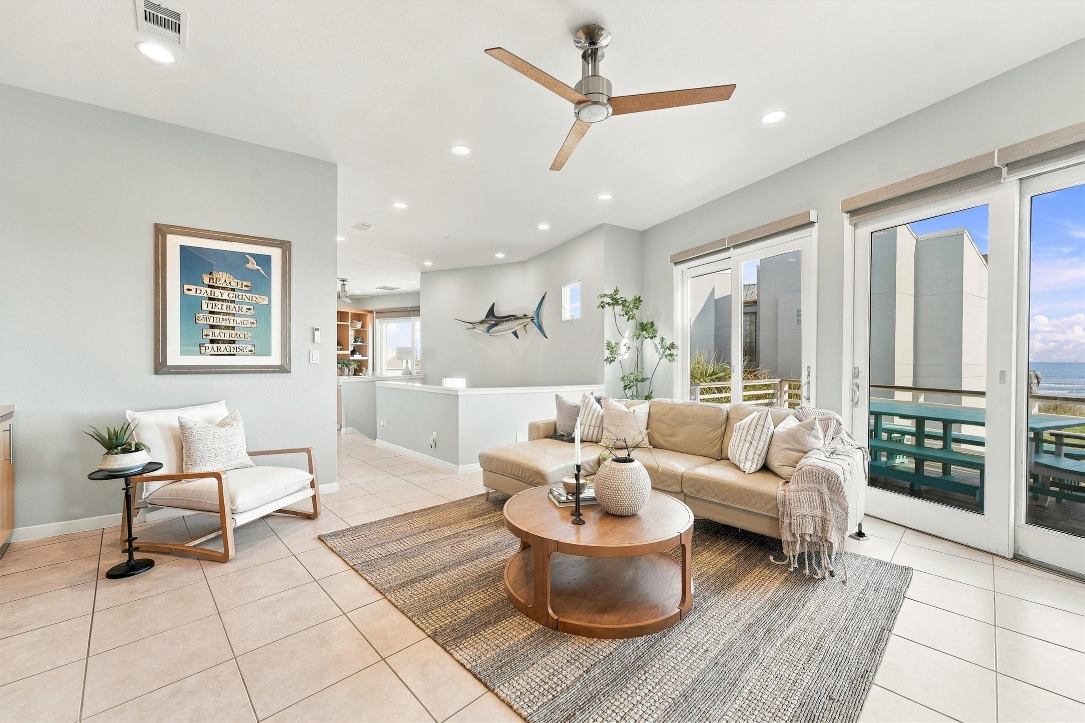 Gather for conversation, curl up after a beach day, or step onto the balcony to enjoy the coastal breeze. Sunlight and water views fill this inviting living space, keeping the shoreline part of every gathering. Gather for conversation, curl up after a beach day, or step onto the balcony to enjoy the coastal breeze. Sunlight and water views fill this inviting living space, keeping the shoreline part of every gathering.