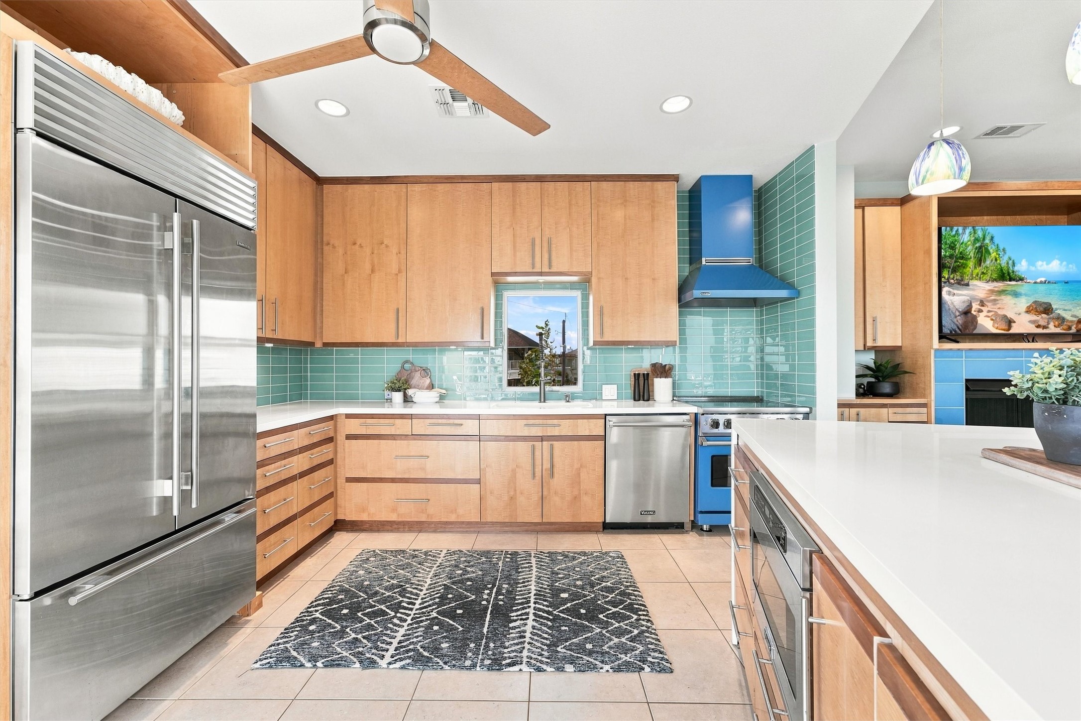 Let the island inspire your next meal. A bold blue range and matching hood complement the seafoam backsplash, while expansive white counters provide plenty of room to prepare, serve, and gather.