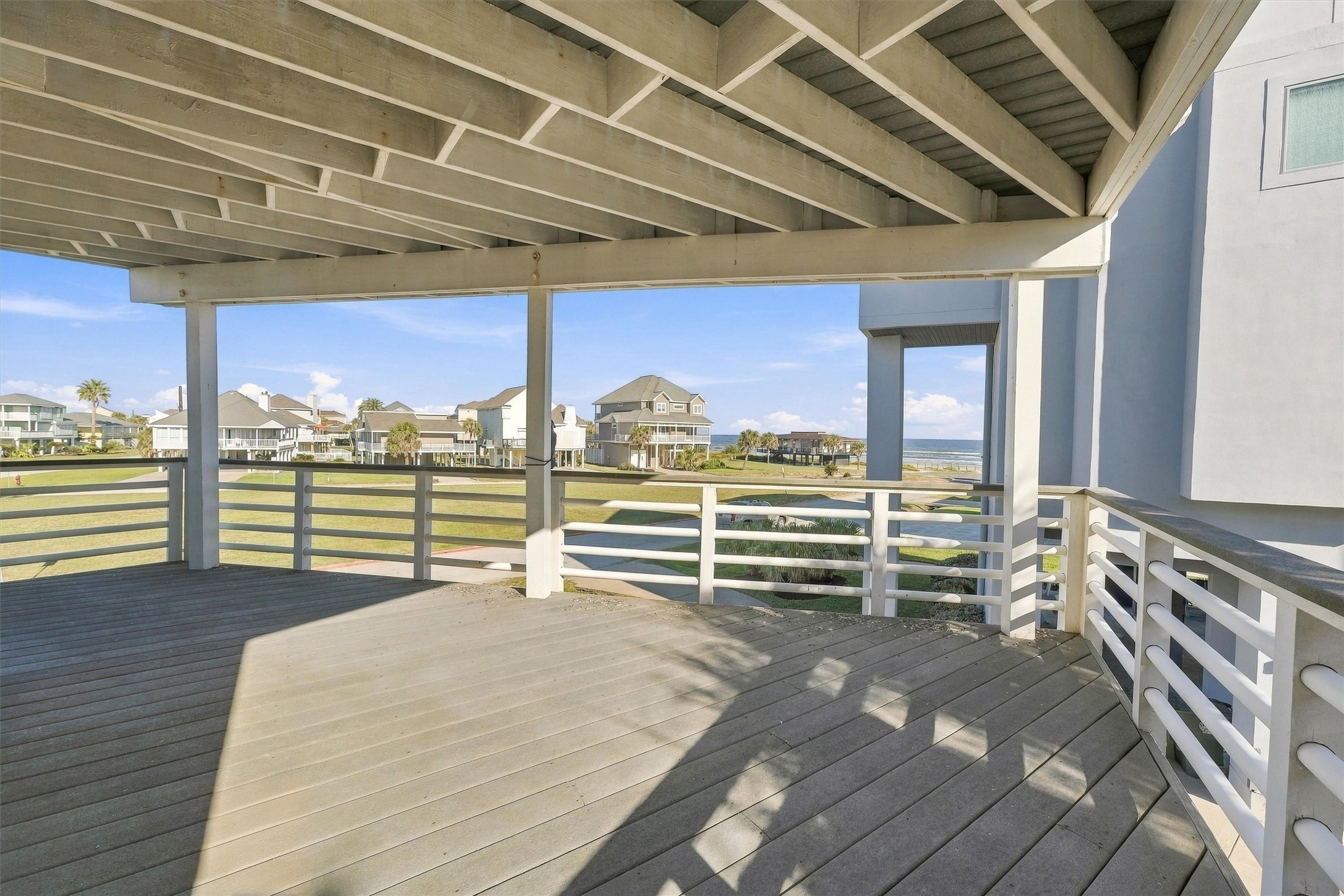 Enjoy your morning coffee in the shade as waves roll toward shore. This spacious covered balcony offers room for outdoor seating and relaxed gatherings, with beach views.
