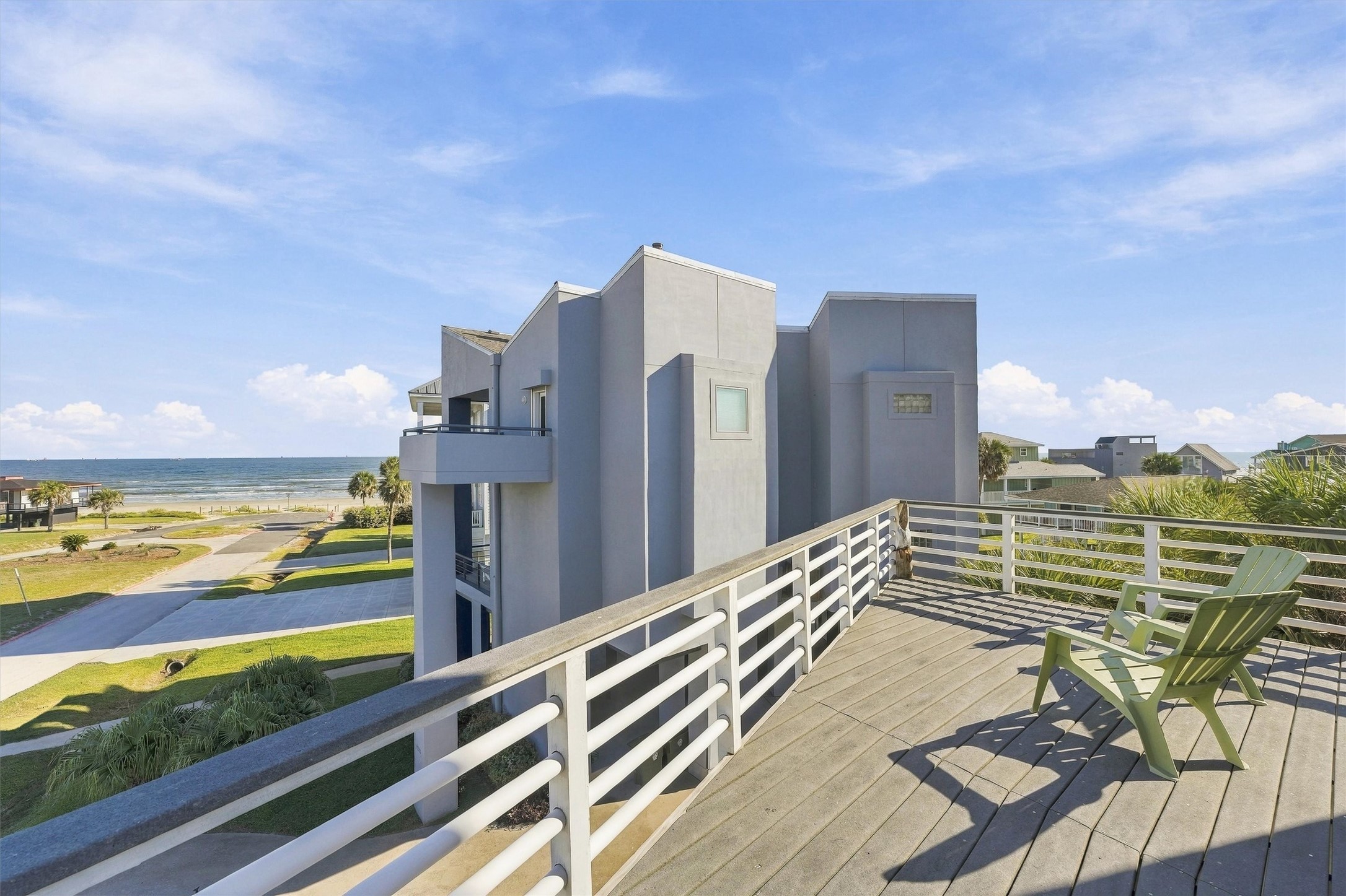 Your next beach walk is just steps away. Looking out across the neighborhood toward the sand and water, this balcony view captures the easy connection between home and shore.