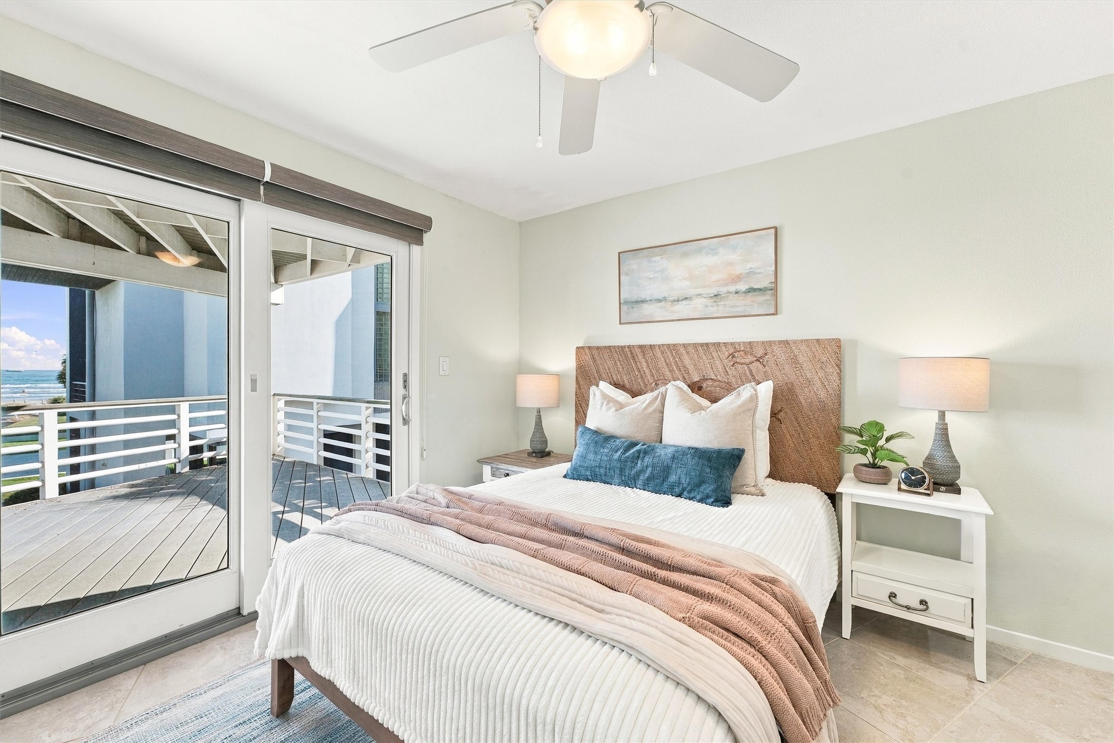 Slide open the doors and ease into island time. This restful bedroom pairs soft coastal tones with covered balcony access and a glimpse of the waves beyond.