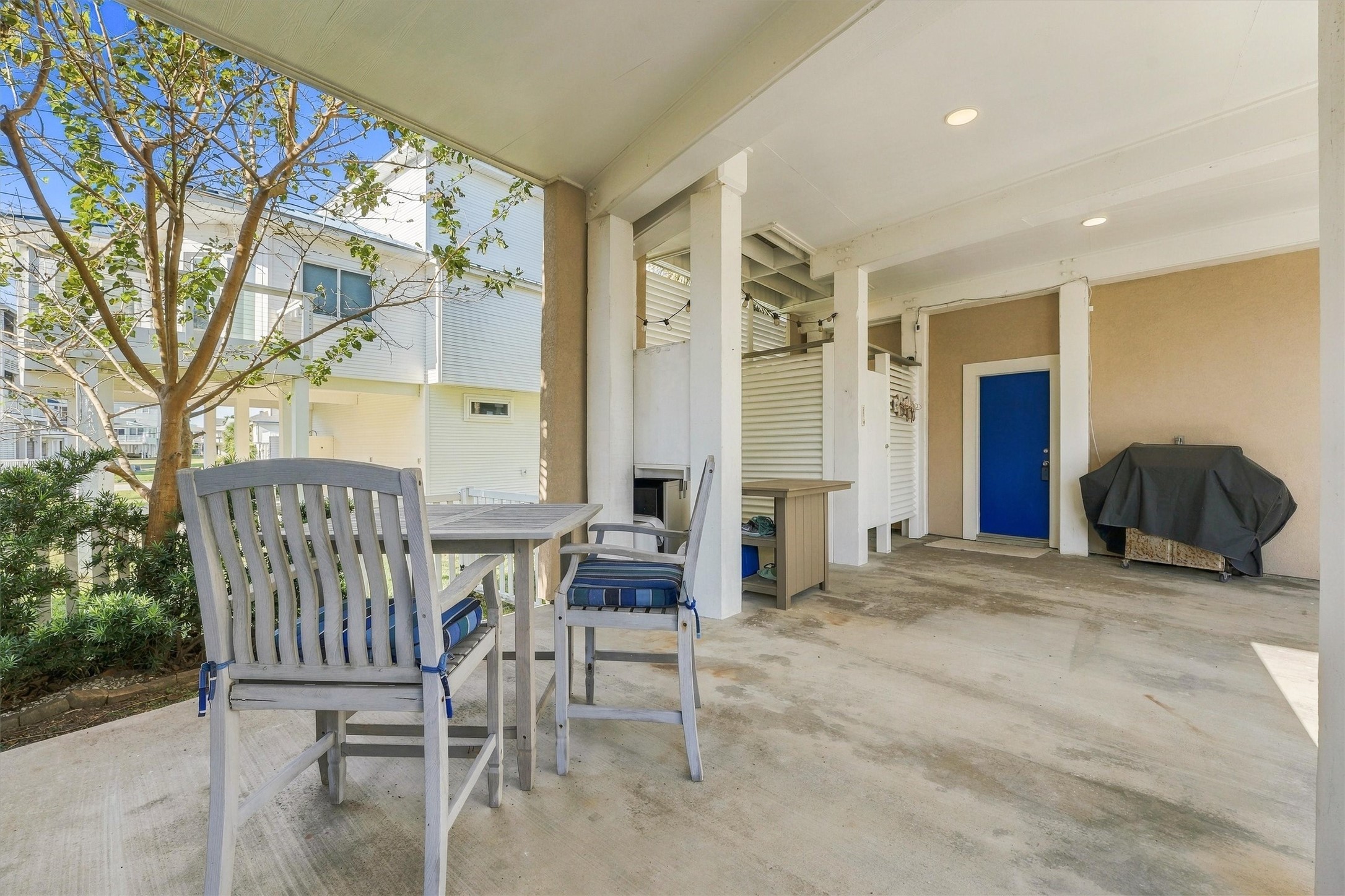 Gather downstairs for a casual cookout after a sun-filled beach day. A shaded dining area and nearby grill create an easygoing setting for sharing a meal and recounting the days adventures.