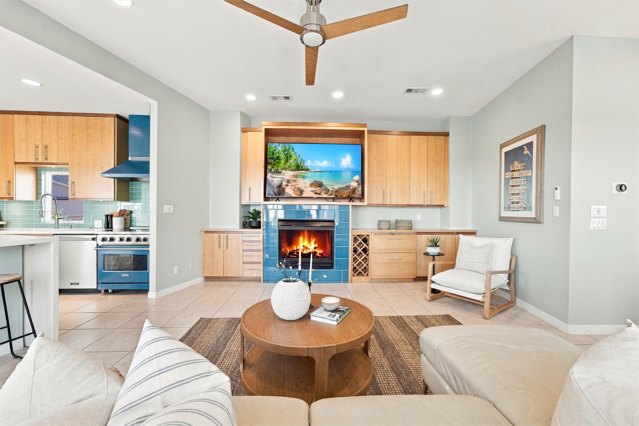 Settle in beside the fireplace. Enjoy a glass of wine, or a beverage from the 2 refrigerator drawers built in, framing this welcoming gathering space, while the open kitchen keeps the conversation flowing. Settle in beside the fireplace. Enjoy a glass of wine, or a beverage from the 2 refrigerator drawers built in, framing this welcoming gathering space, while the open kitchen keeps the conversation flowing.