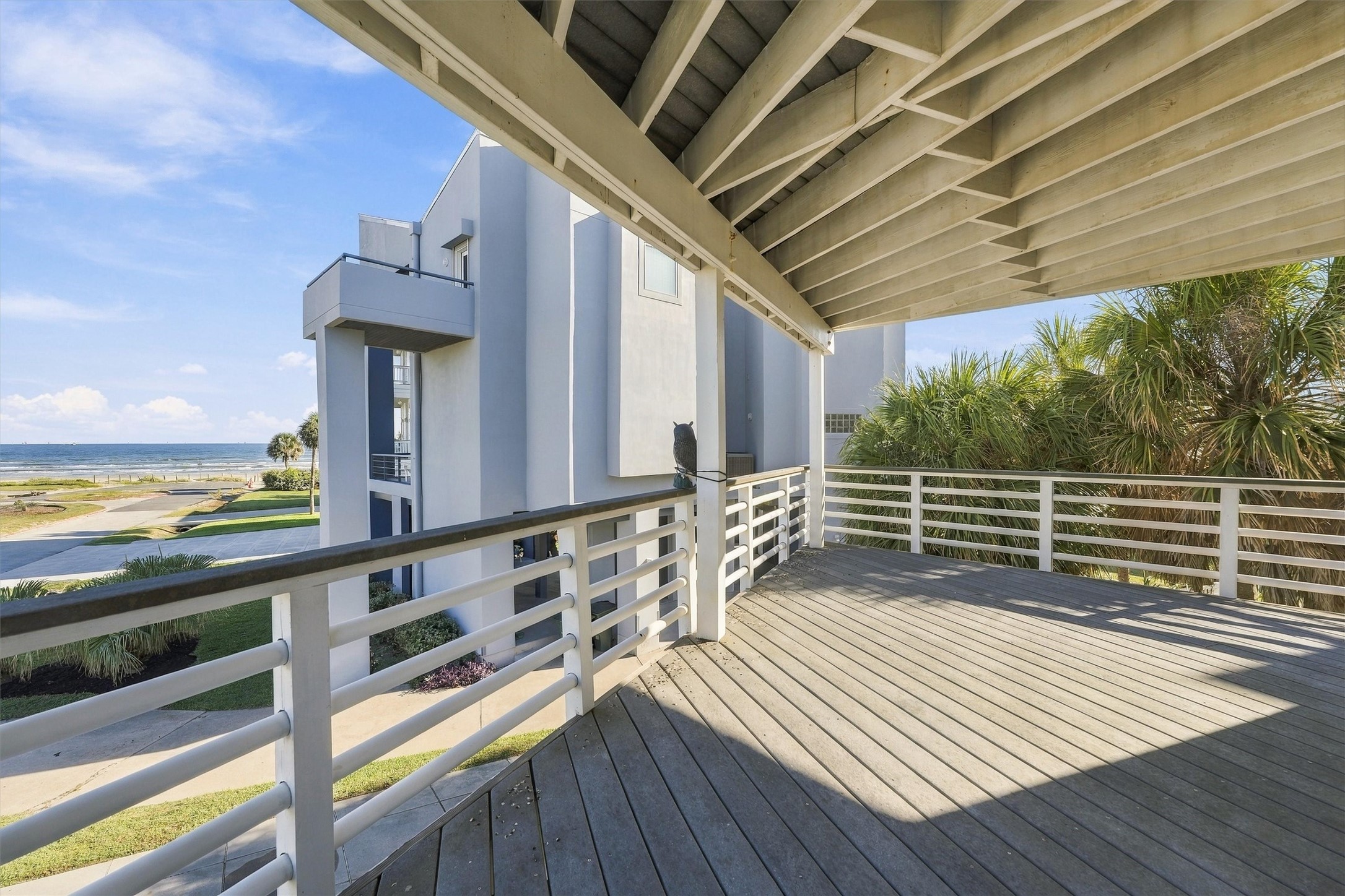 Palm trees frame a peaceful spot to unwind. With generous covered space and water views, this balcony invites you to settle in and enjoy the coastal breeze.