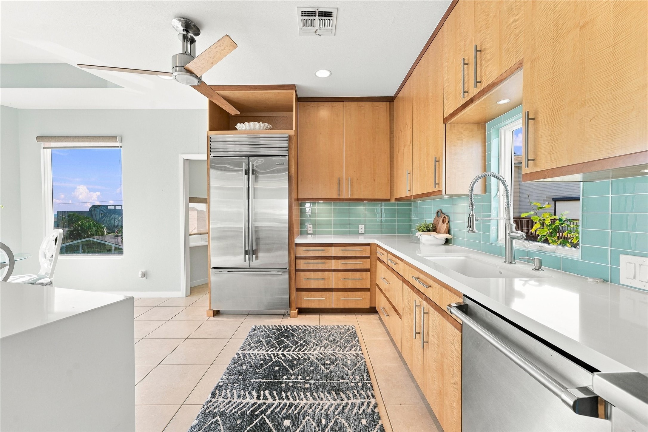 Generous cabinetry, a built-in stainless refrigerator, and ample counter space make this kitchen ready for everything from quick beach snacks to luxury dinners.