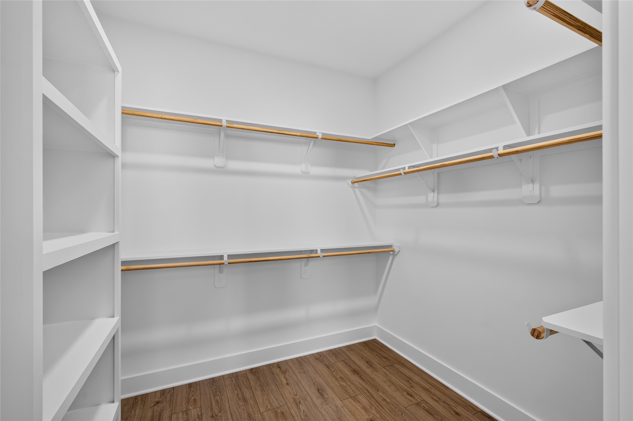 Large walk in closet with built in shelving provide exceptional storage and organization in the primary suite.