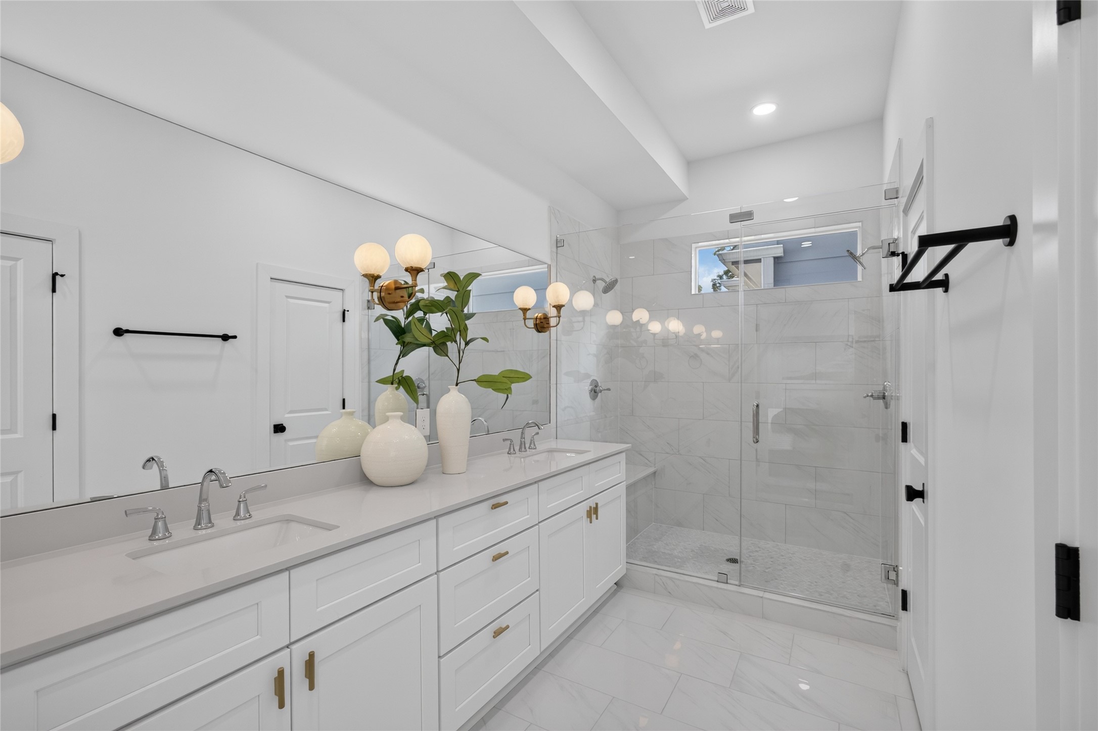 Elegant primary bathroom featuring dual vanities, quartz countertops, and modern designer finishes.