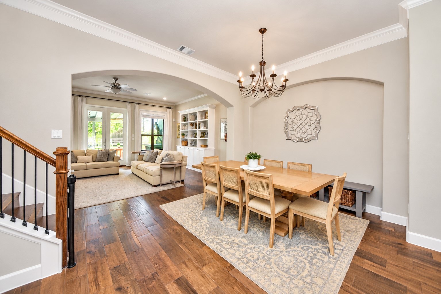 Open dining and kitchen area featuring beautiful wood flooring, a statement chandelier, and plenty of space for entertaining.