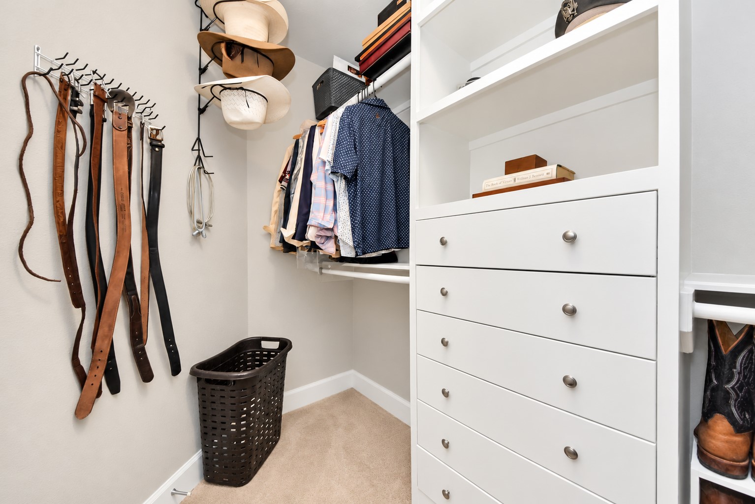 Primary walk-in closet with built-in drawers, shelving, and organized storage for clothing and accessories.