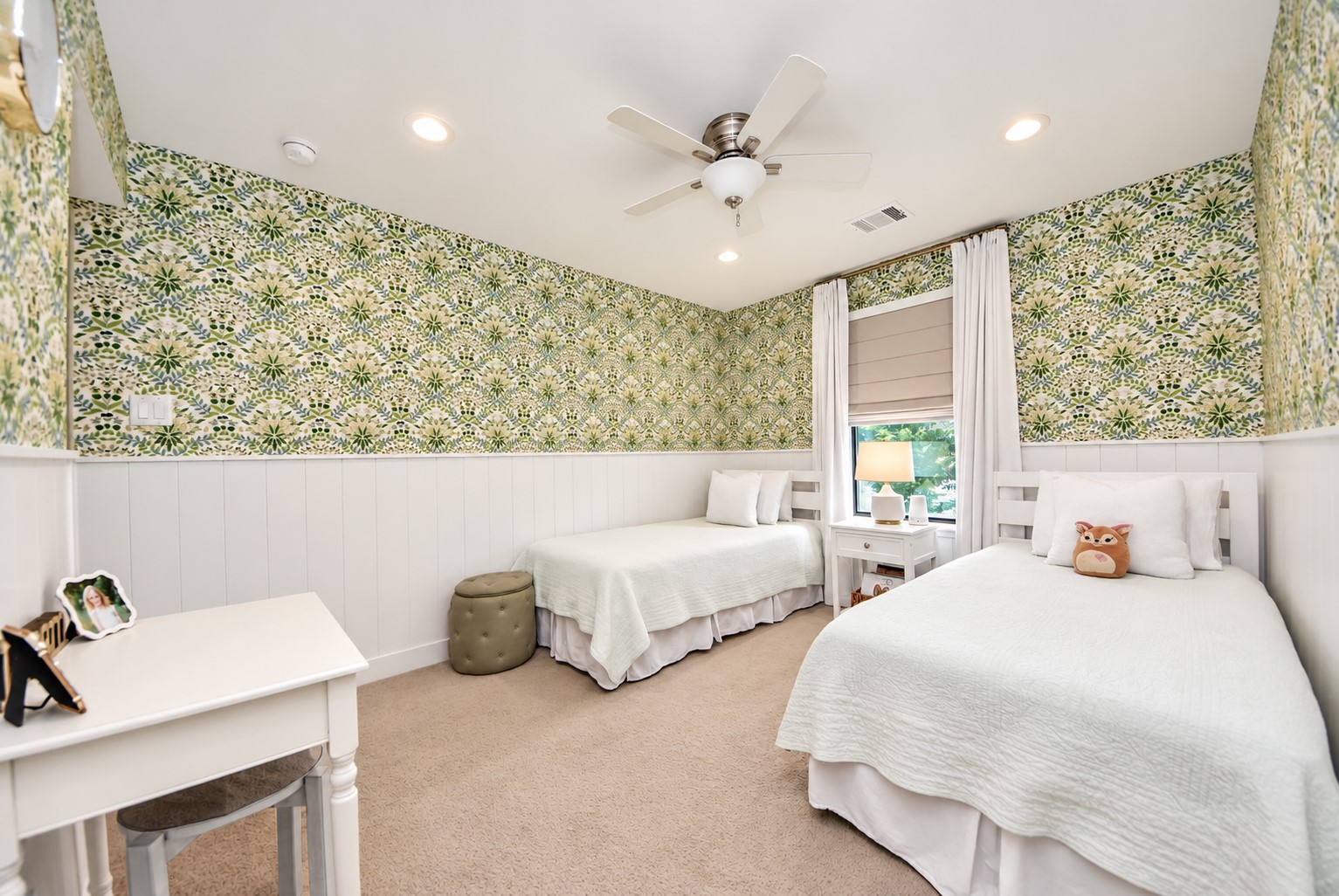 Another view highlighting the beautiful custom wallpaper, white wainscoting, and thoughtful design details that give this bedroom its distinctive charm.