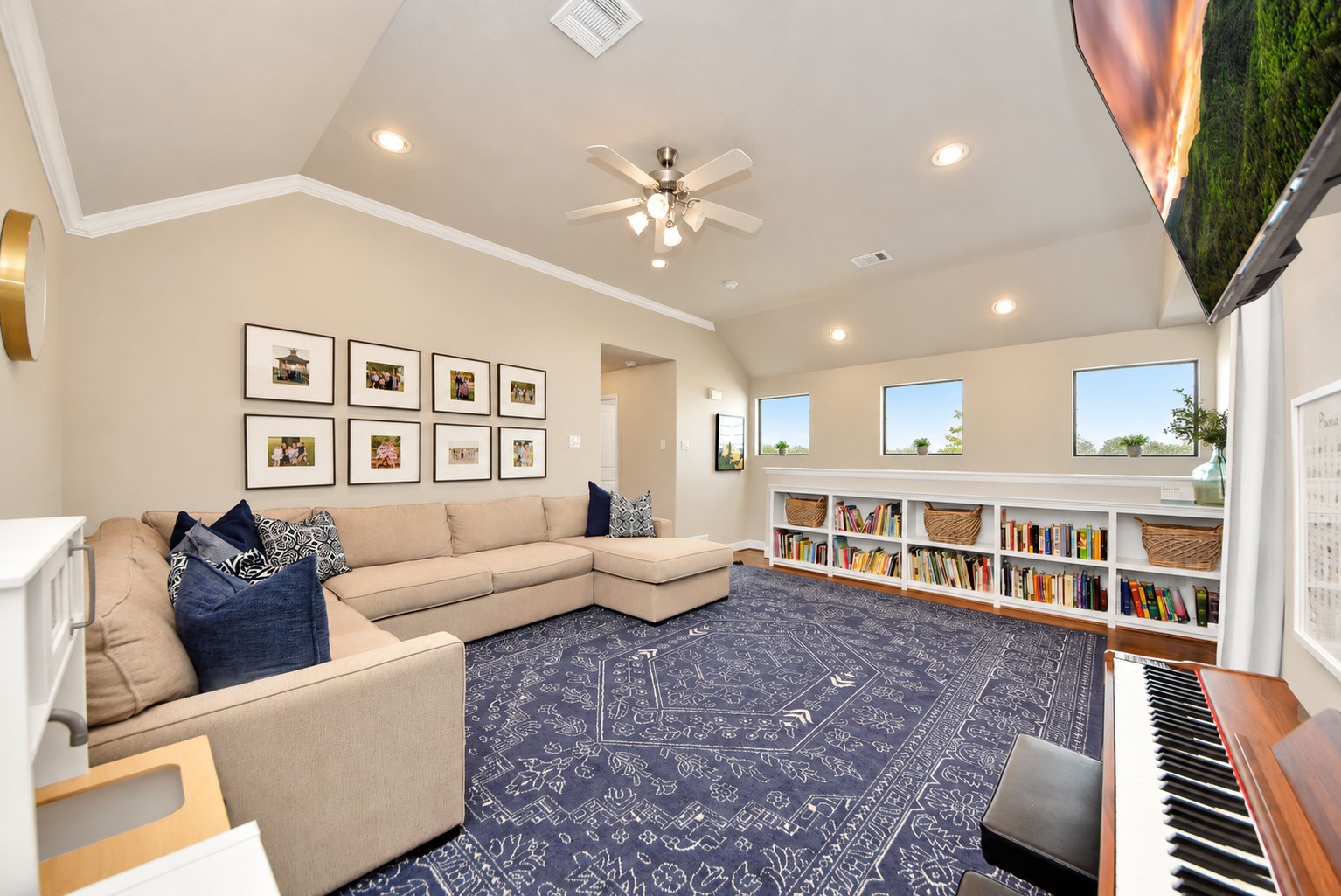 Another view of the expansive game room showcasing the vaulted ceiling, recessed lighting, custom built-ins, and versatile layout perfect for a media room or entertainment space.