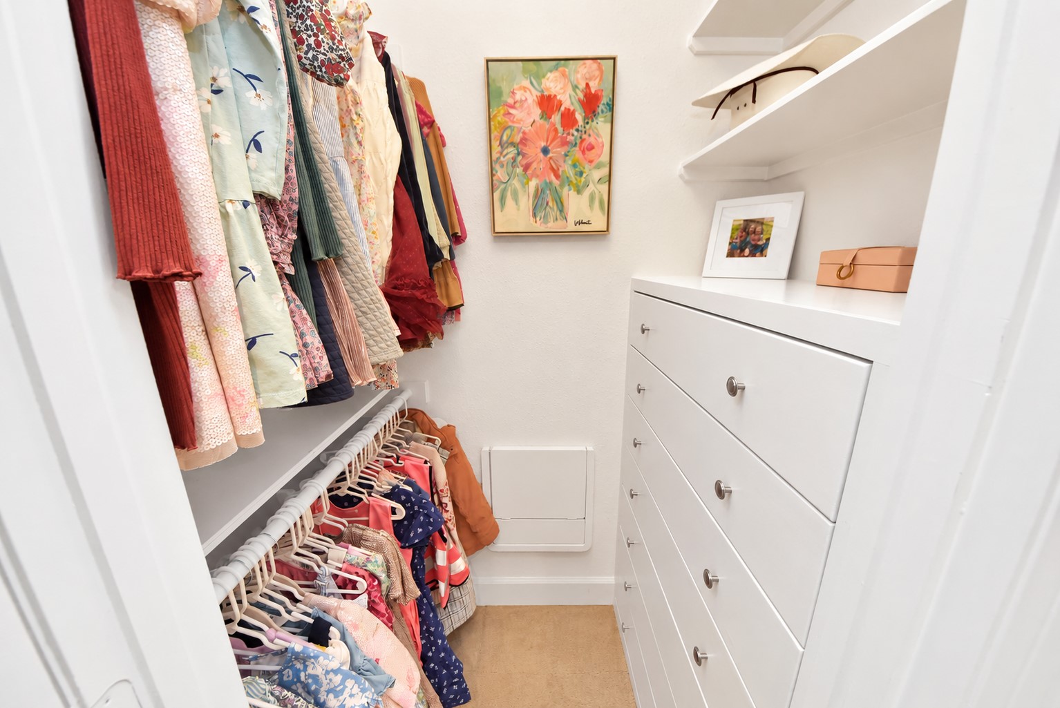 Well-organized walk-in closet featuring built-in drawers, generous shelving, and double hanging rods to maximize storage and functionality.