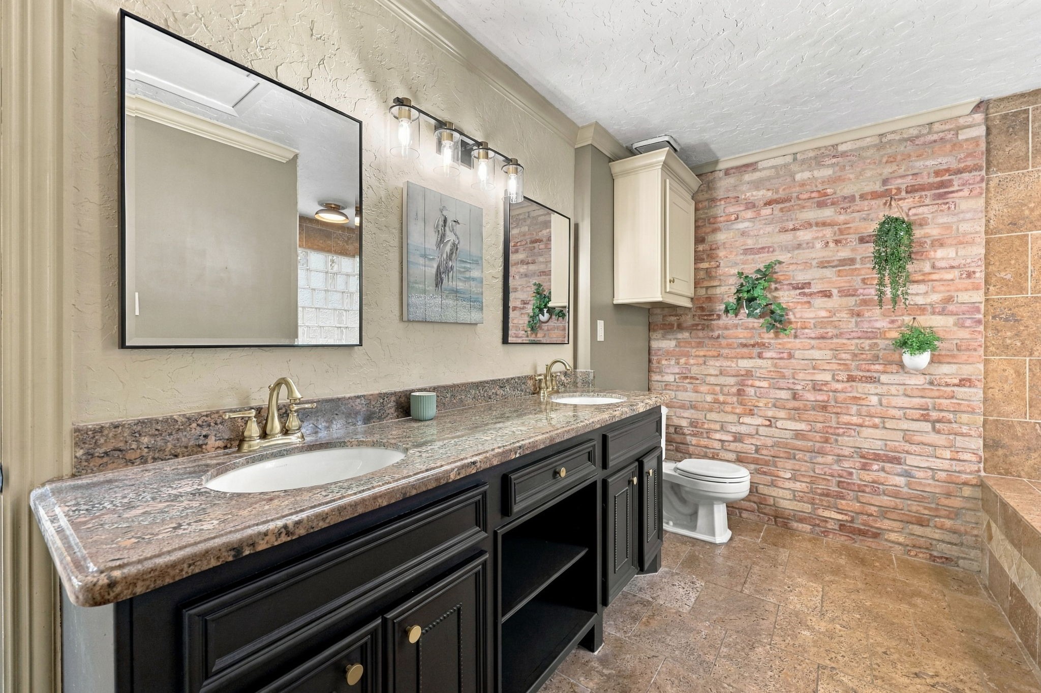 Primary Bath at back of house with double sinks and brick wall accent
