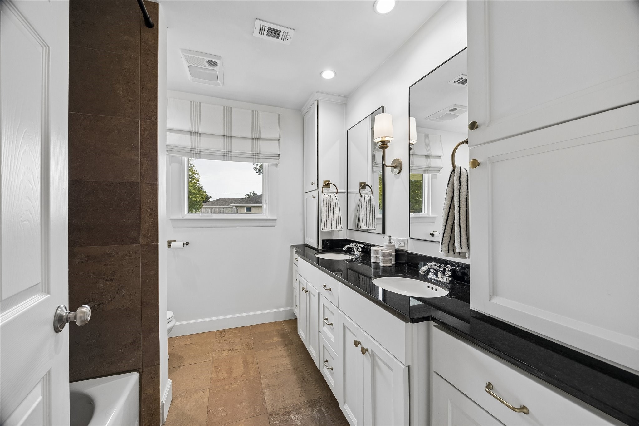 Secondary bath with shower/tub combo and double sinks.
