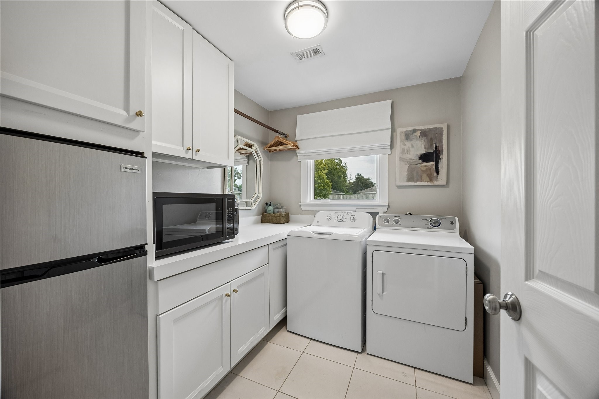 Nicely sized utility room with fridge/freezer combo.