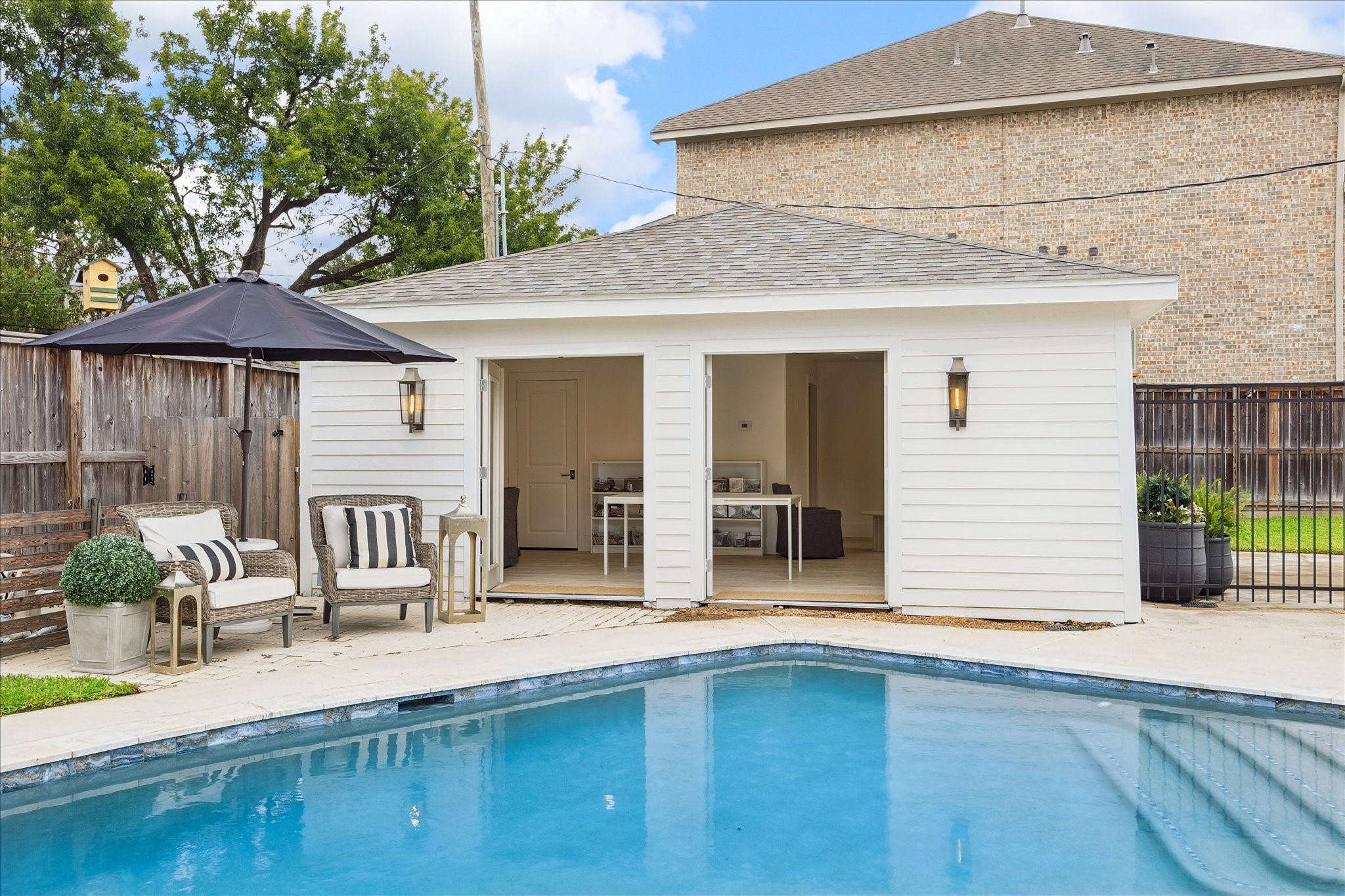 Reimagined in 2026, the previous 2 car garage is now an exceptional pool house/guest space with a full bathroom and walk-in closet. 2 sets of French doors that open to the pool.