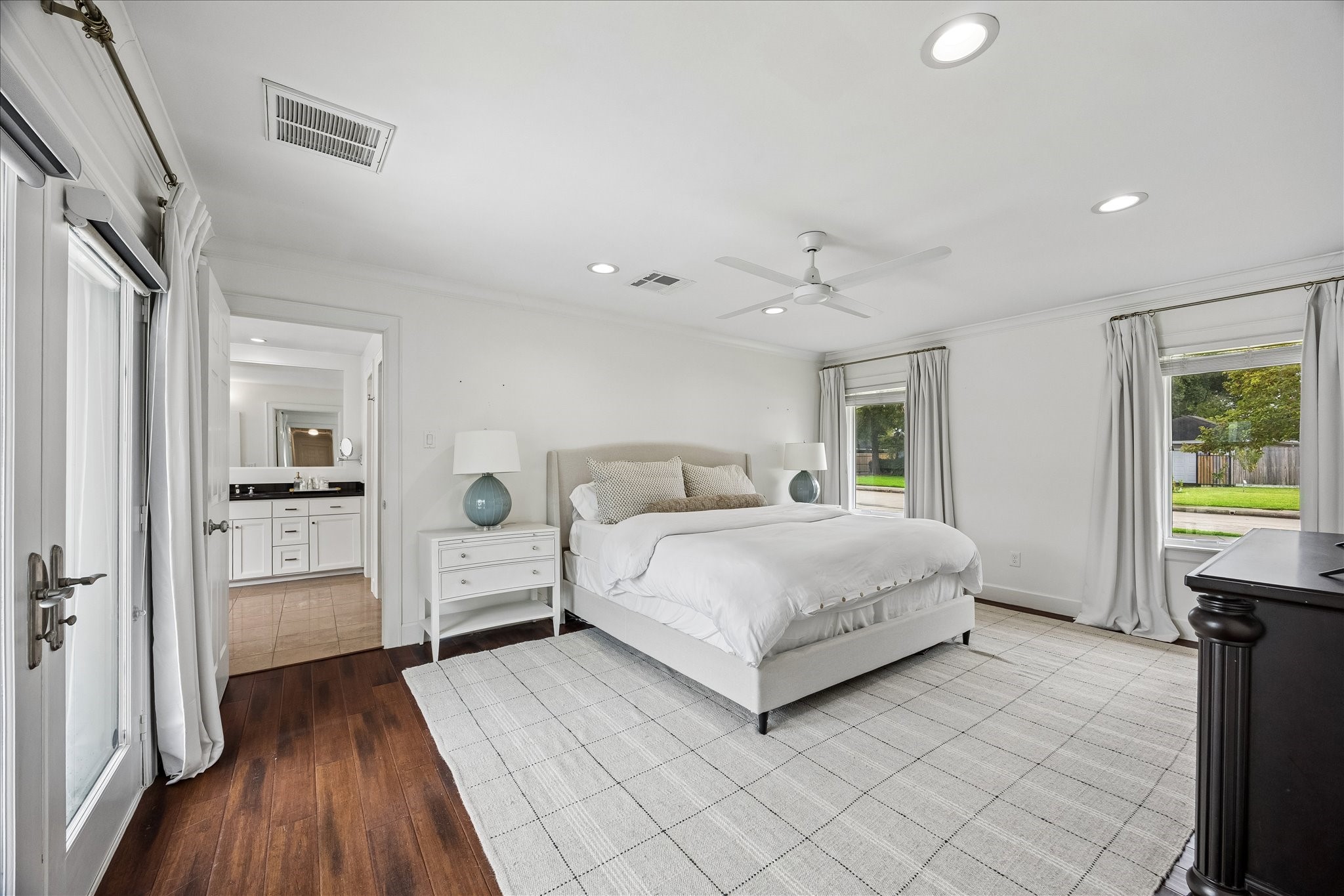 The large primary suite offers natural light with windows and French doors leading to the outdoor oasis. The large primary suite offers natural light with windows and French doors leading to the outdoor oasis.
