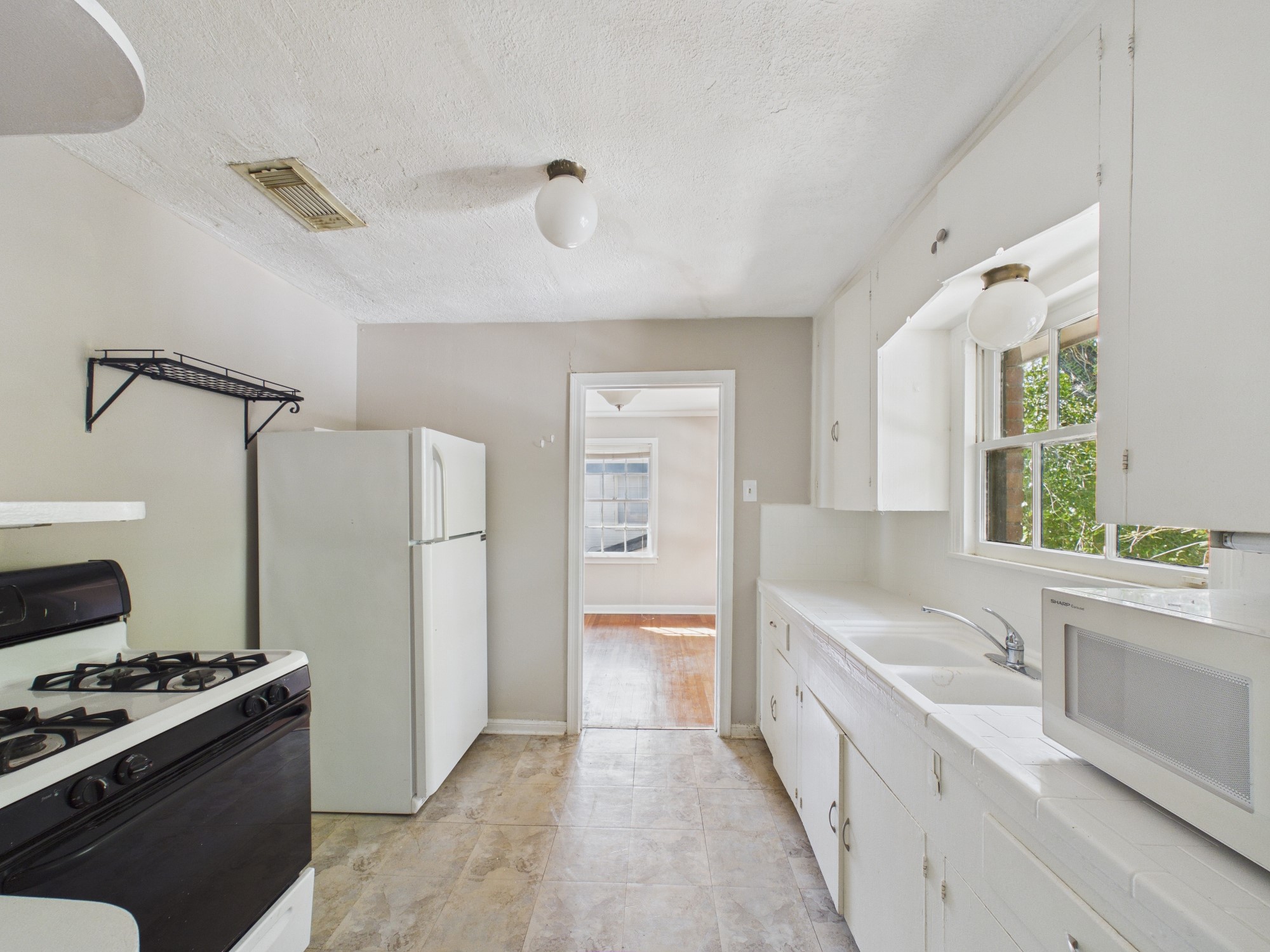 Kitchen with Tile Counters, White Refrigerator & Gas Range