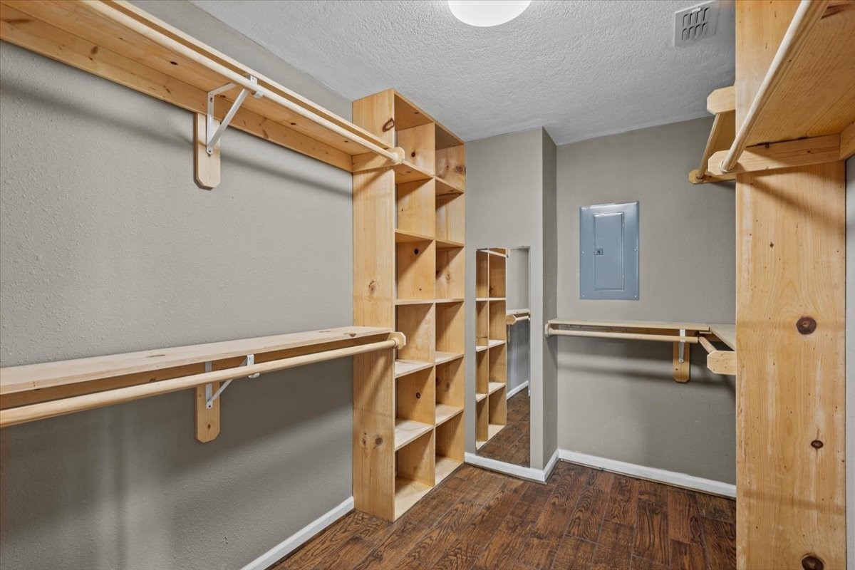 Primary walk-in closet with built in shelving.