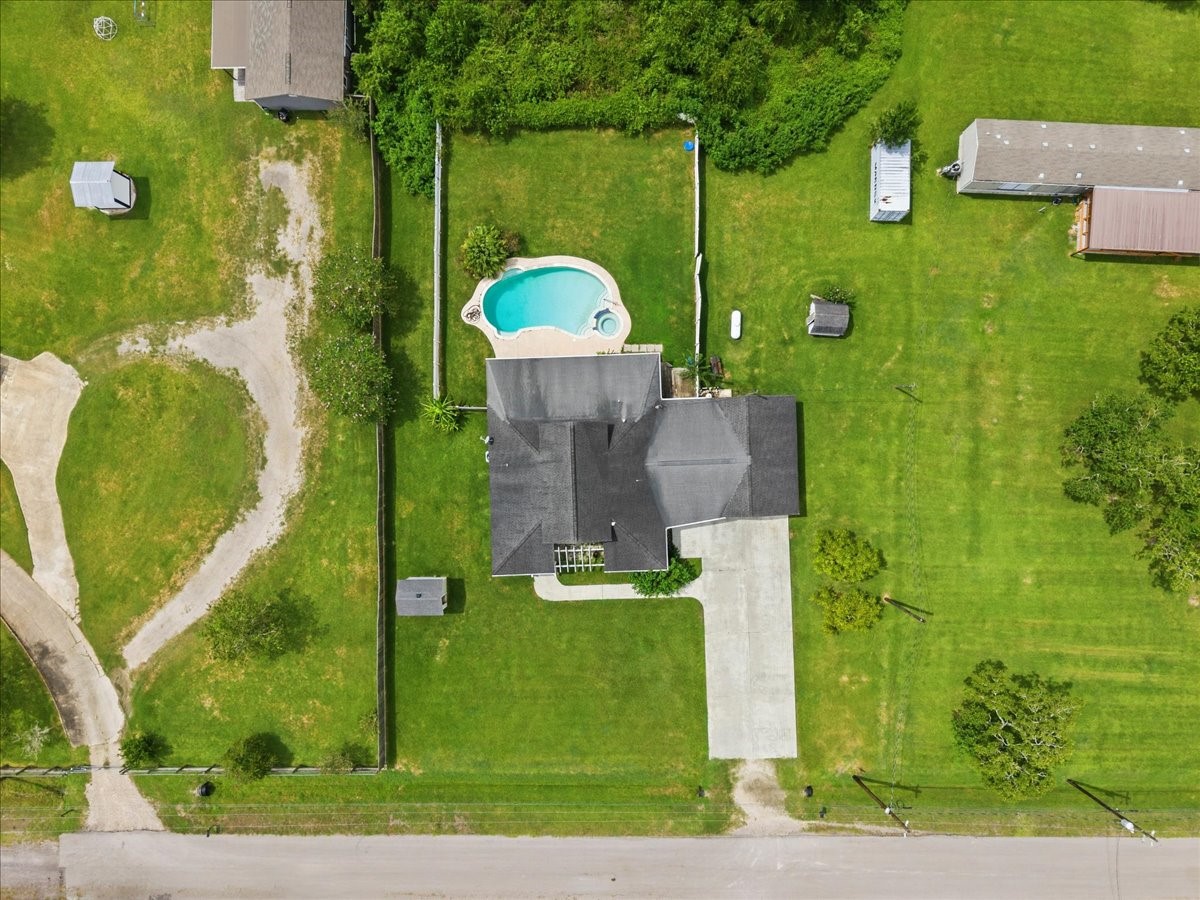 Well house on the front left side and storage building on back right side.