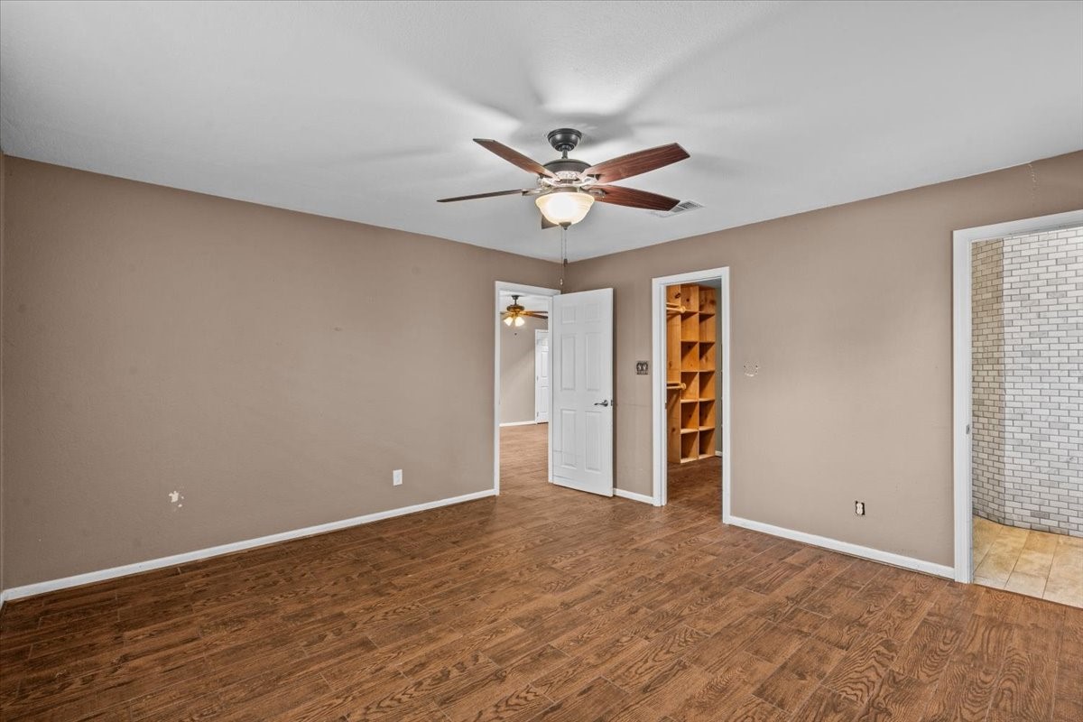 Primary bedroom with door to en-suite bathroom and walk in closet with built in shelving.