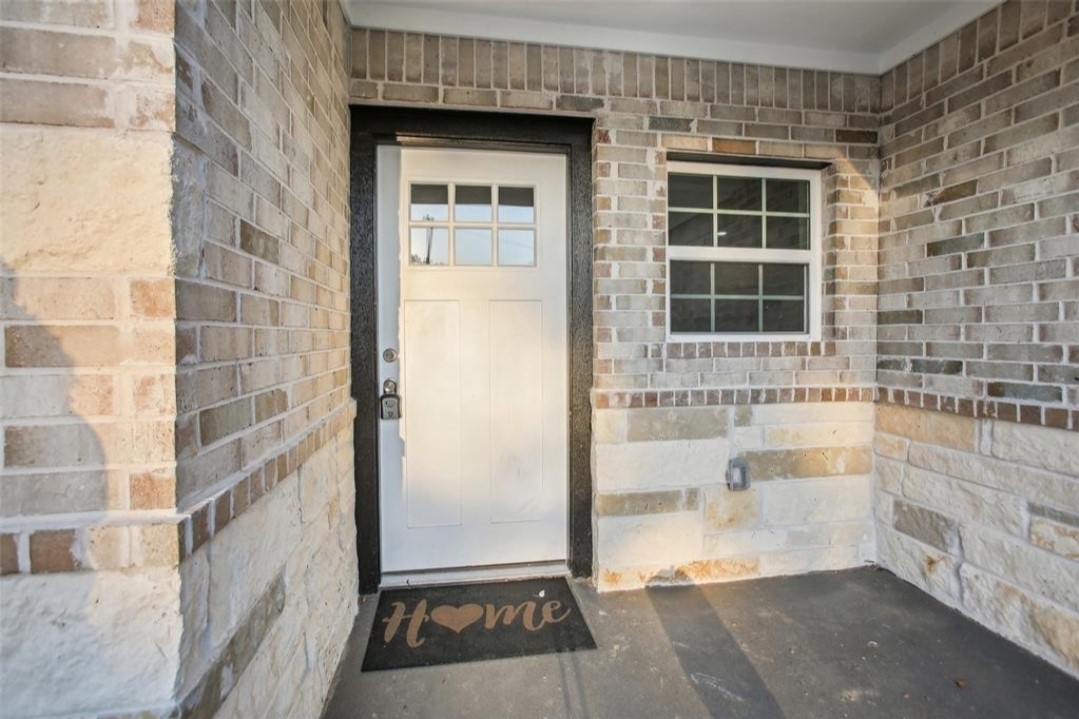 Multi panel front door with brick surround front porch