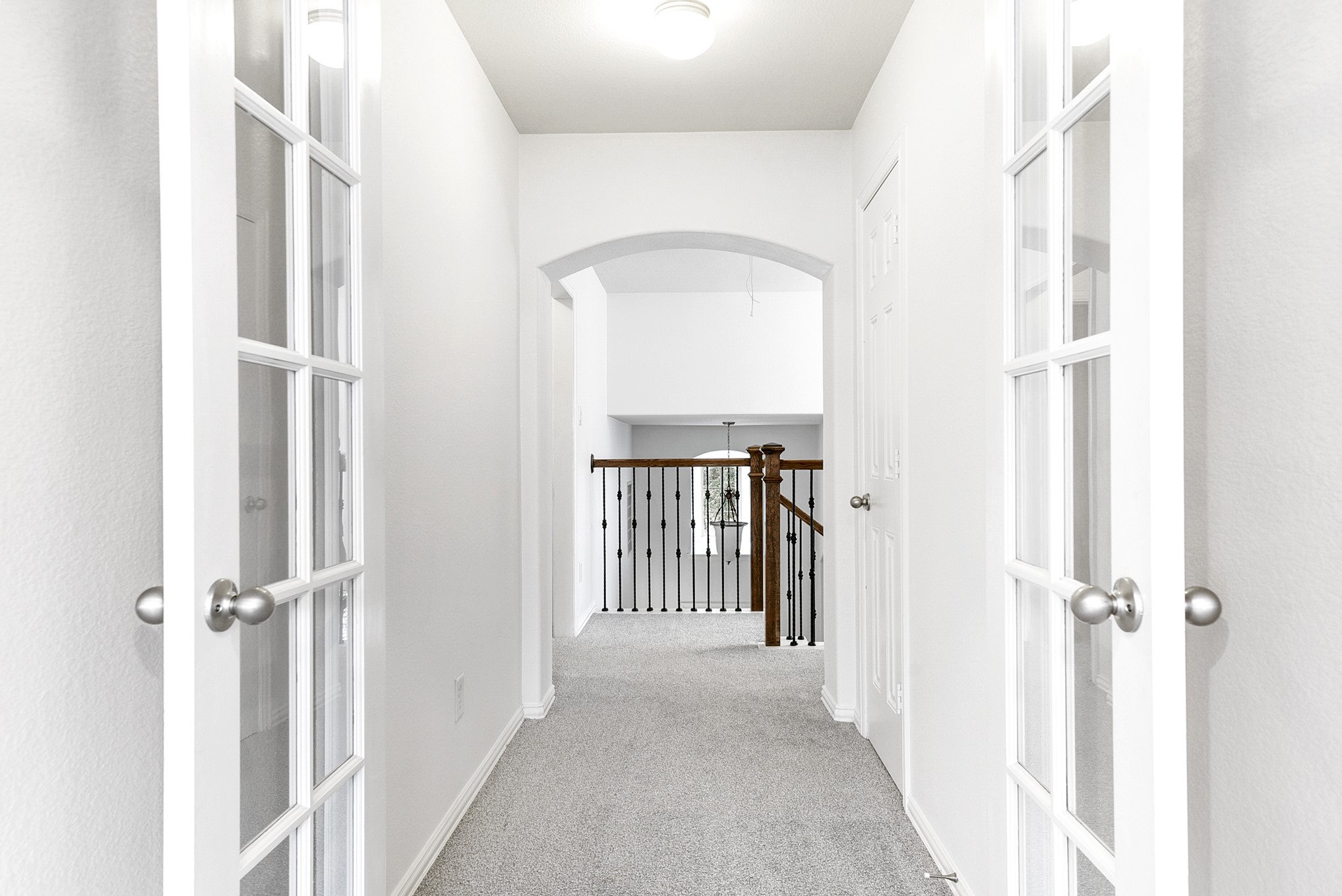 This is a view from the upstairs media room, looking out toward the staircase, providing a clear perspective of the homes layout and flow between levels.