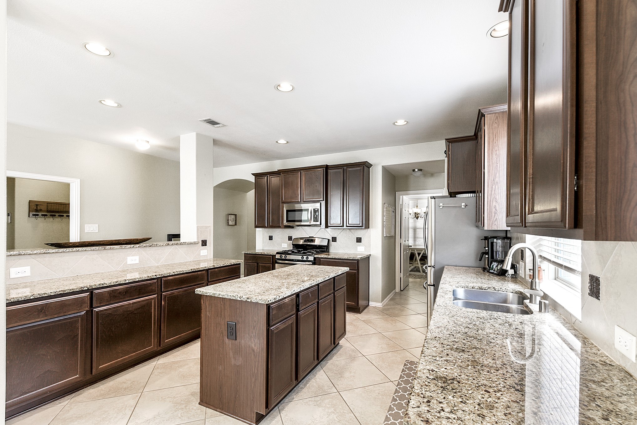 The kitchen features a large window above the sink, allowing natural light to illuminate the space and providing a pleasant view while working in the kitchen.