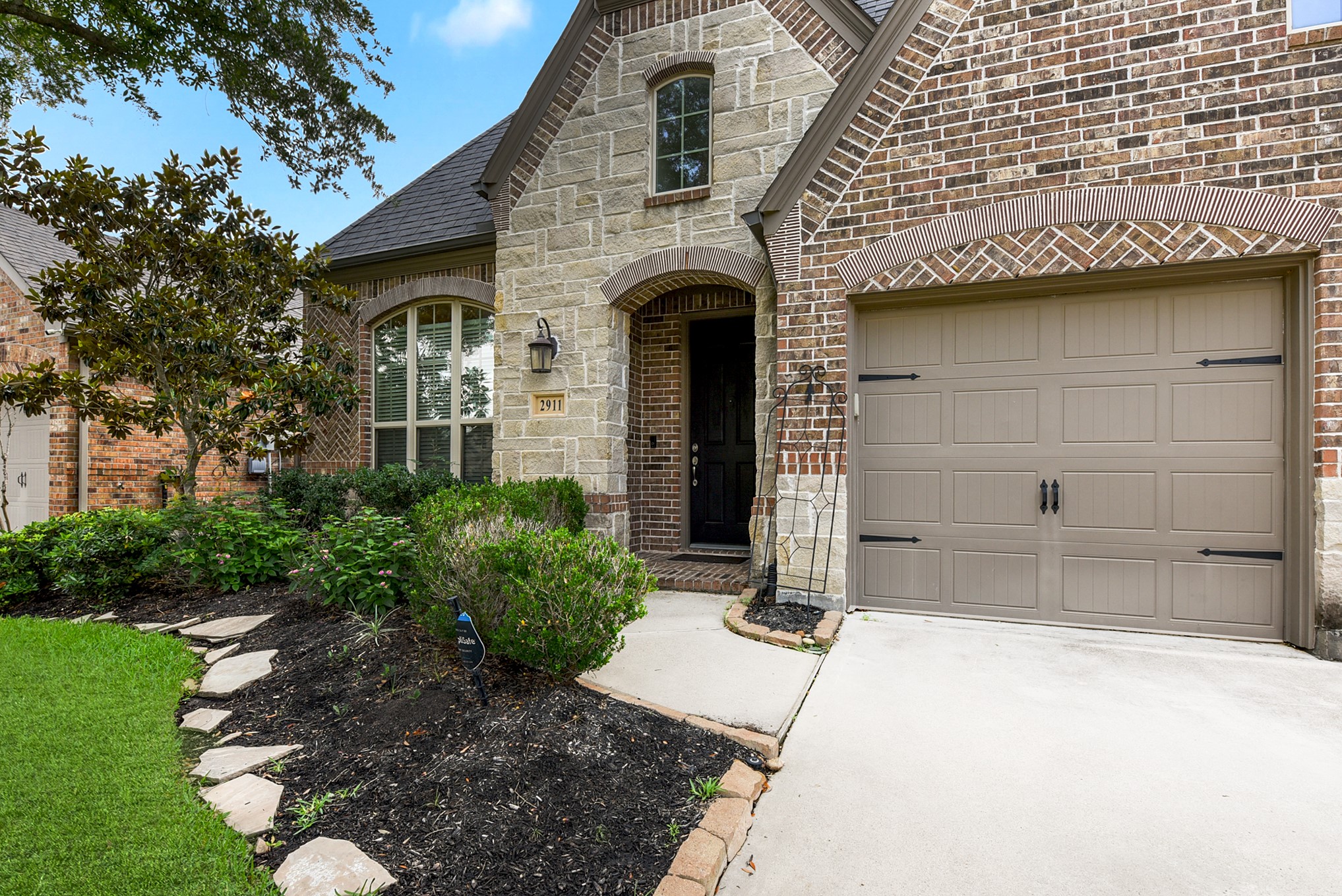 Featuring a lengthy driveway, providing additional parking space or an area for outdoor activities. A pathway leads to the covered front door, welcoming you to the home.