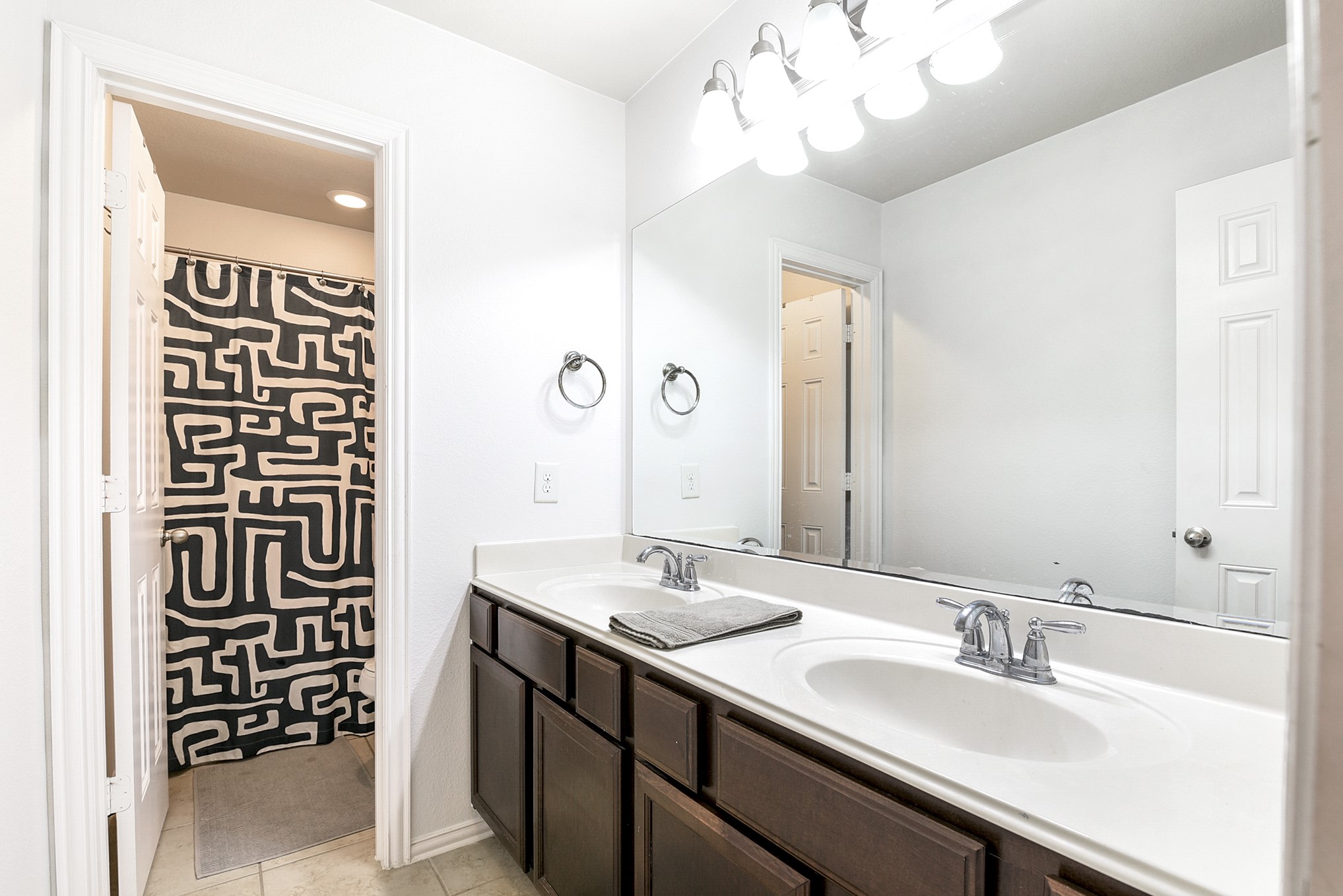 The upstairs guest bathroom features dual sinks and dual doors, making it ideal for multiple users.