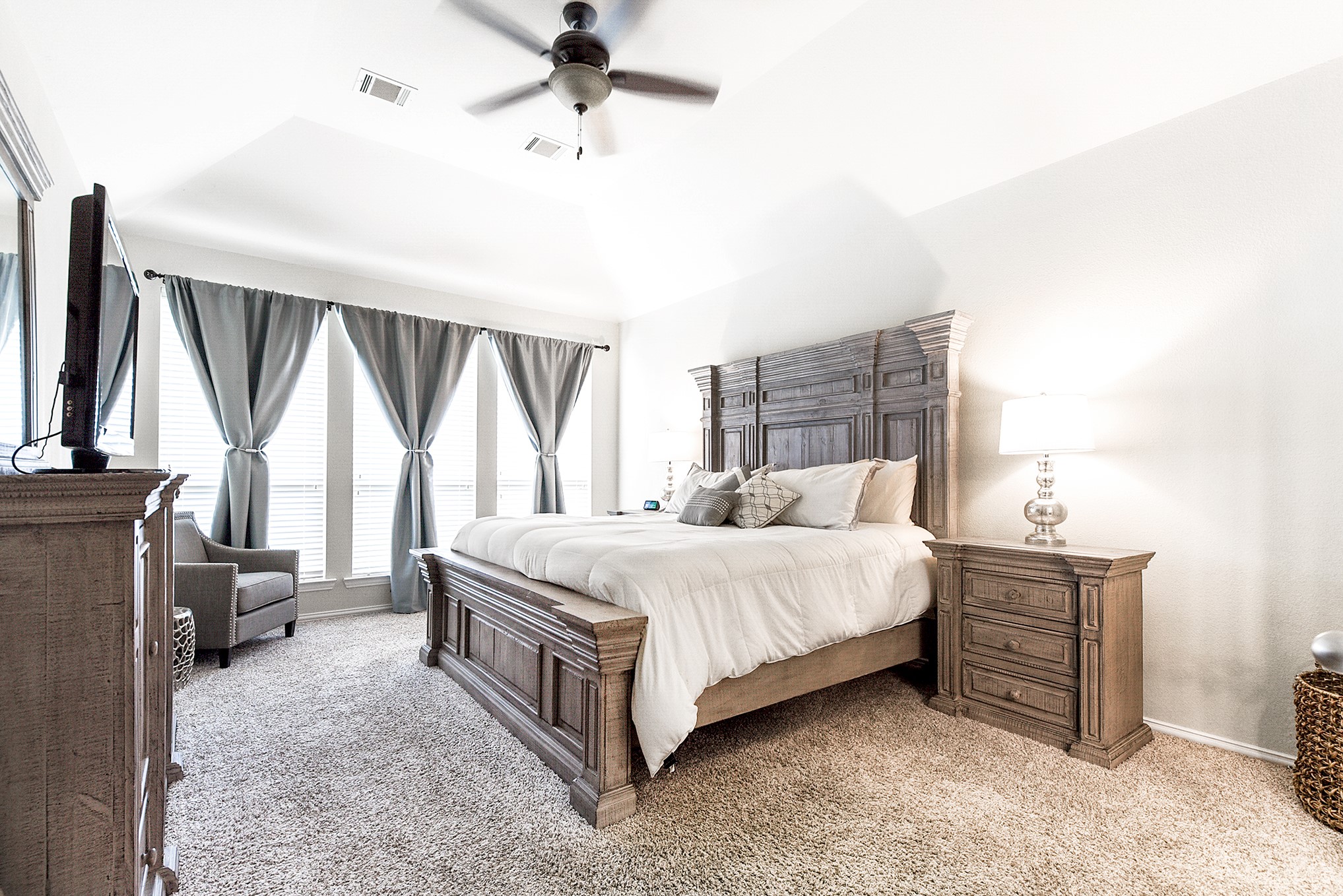 Step into the primary ensuite located on the main floor, where you'll find high ceilings adorned with a drop-down ceiling fan and bay windows offering views of the backyard.