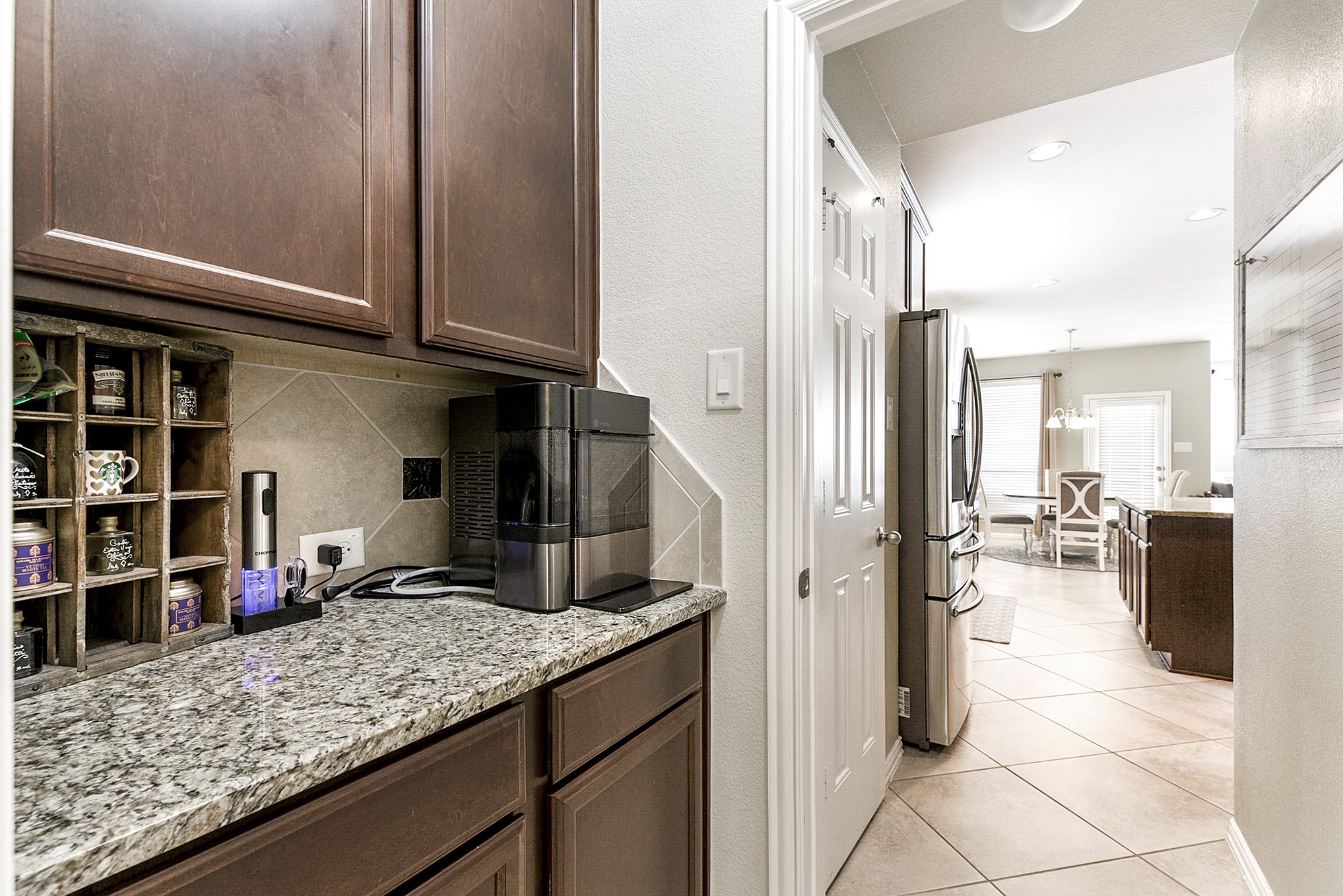 From the dining room, the butler's pantry seamlessly transitions you into the island kitchen. This butler's pantry offers additional counter space and cabinet storage, ideal for a coffee station or wine bar.