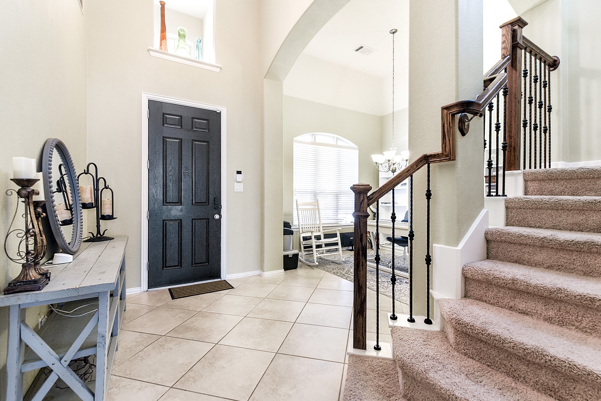 Upon entering the home, you're welcomed by high ceilings in the foyer, creating a spacious and airy atmosphere. Tile flooring extends from the foyer into the living room and kitchen, adding to the seamless flow of the space.
