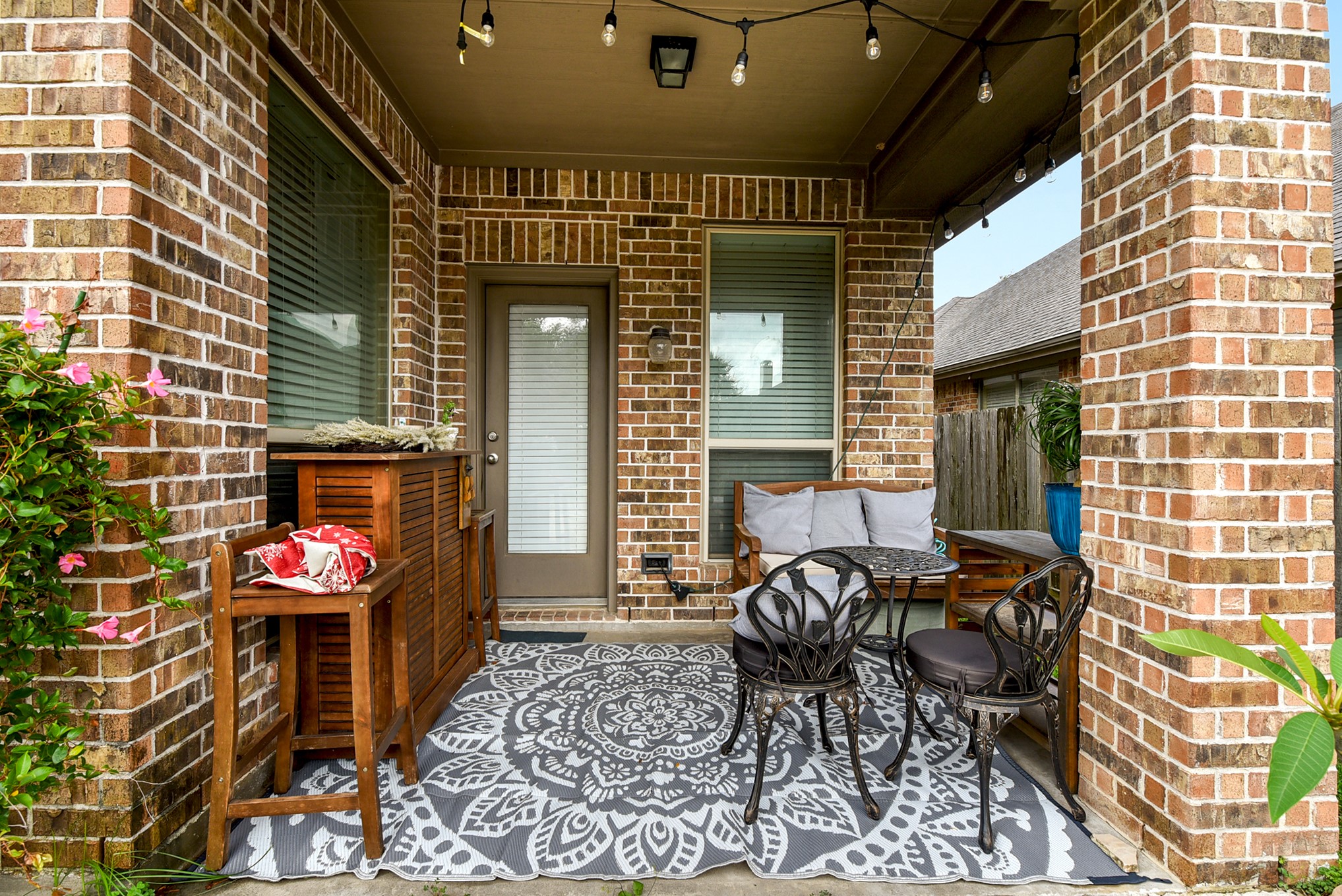 The covered back patio provides ample space for barbecuing or relaxing while watching activities in the backyard, making it the perfect spot for outdoor entertaining and leisure.