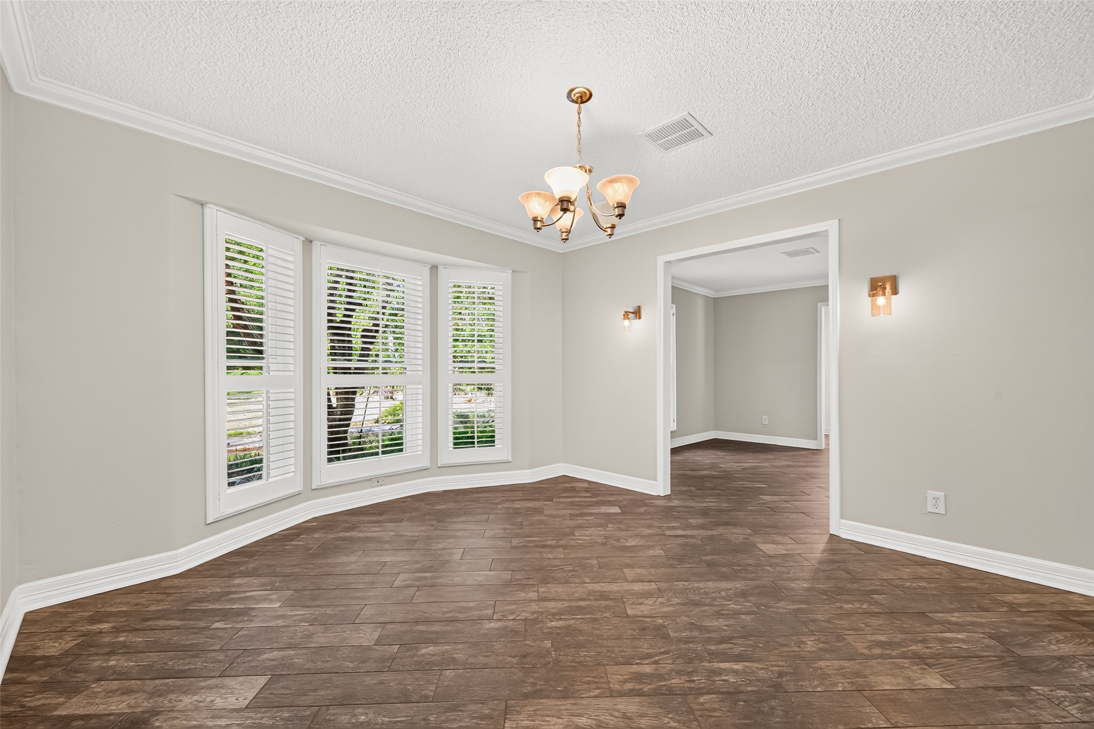 The formal dinnig room is jeweled with custom crown molding and baseboards, custom window shutters, and decorative wall sconce lighting. This will set the mood for elegant dinners and entertaining.