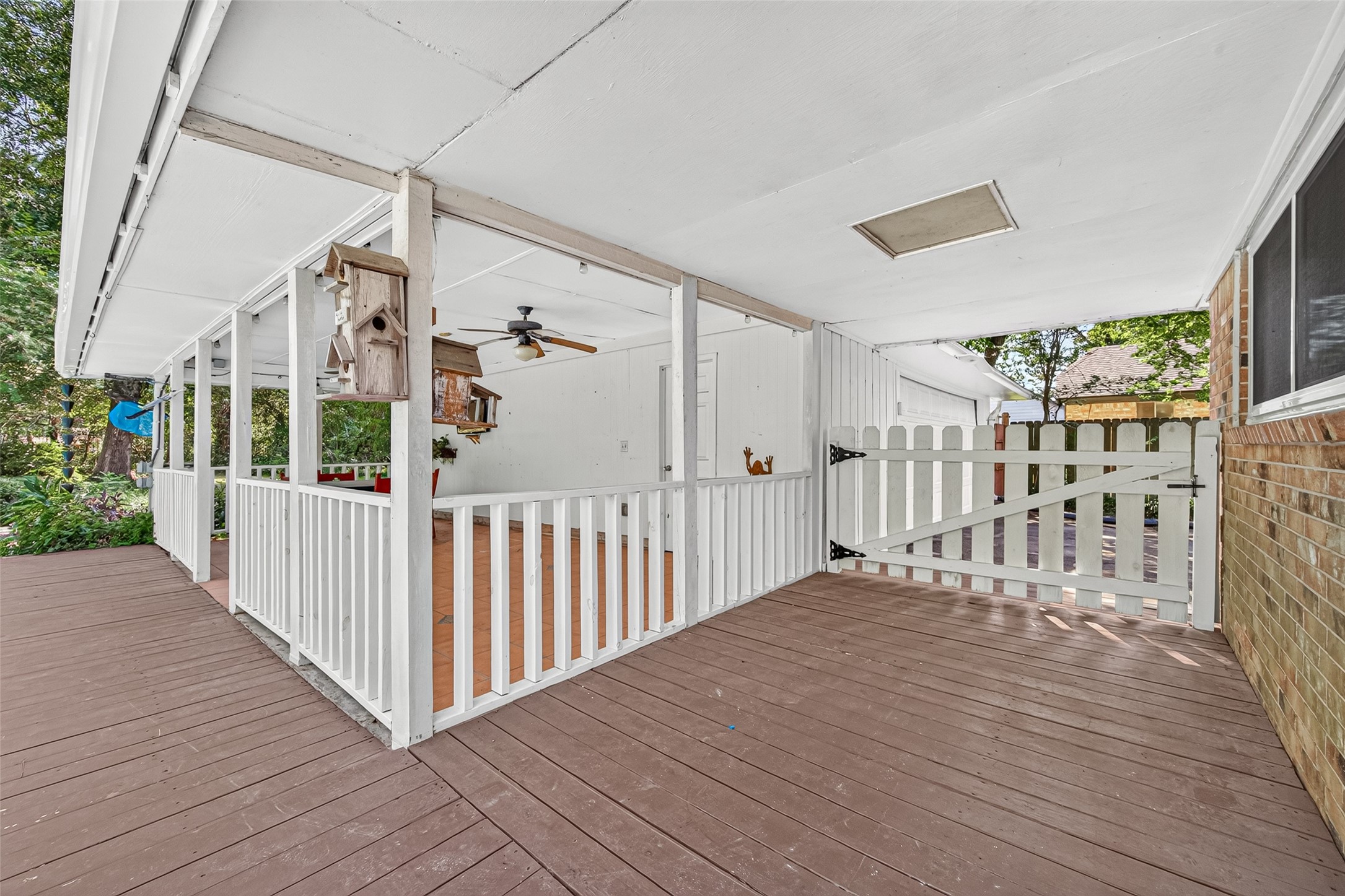 Covered deck patio with wrap around picket fencing and extra large swing gate.