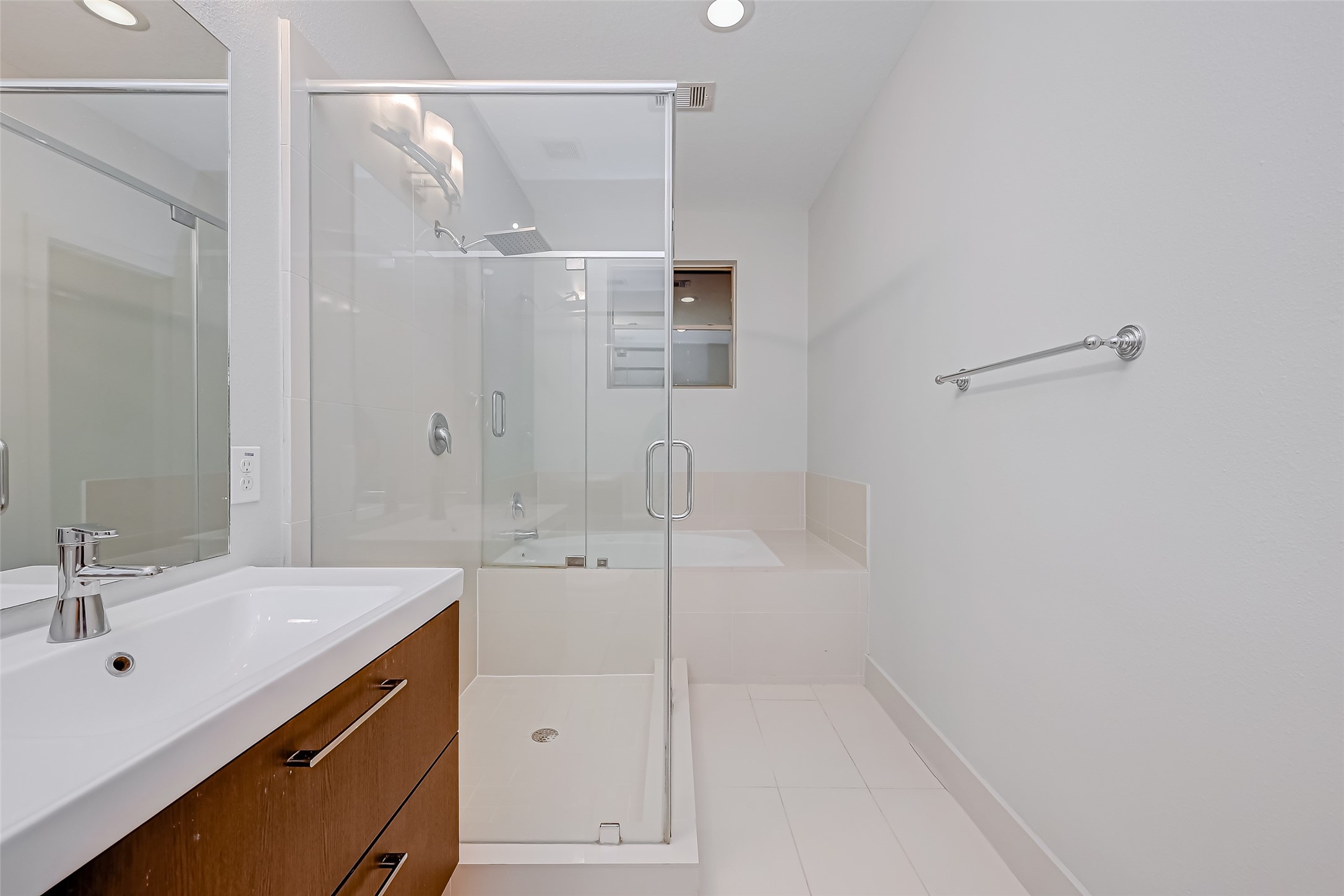 Sleek and modern bathroom featuring a spacious glass-enclosed shower, elegant vanity with ample storage, and a soothing color palette for a relaxing atmosphere.