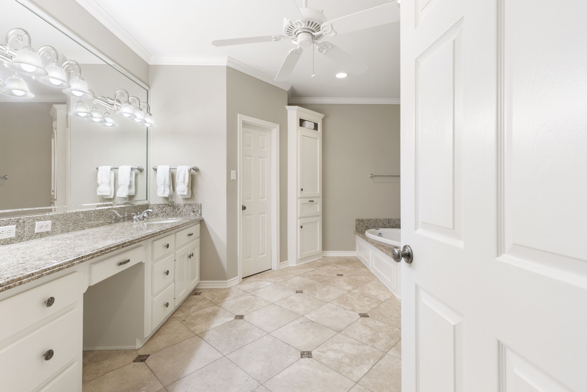 A spacious primary bath pairs an extended vanity with a separate bathing area for a comfortable daily routine.