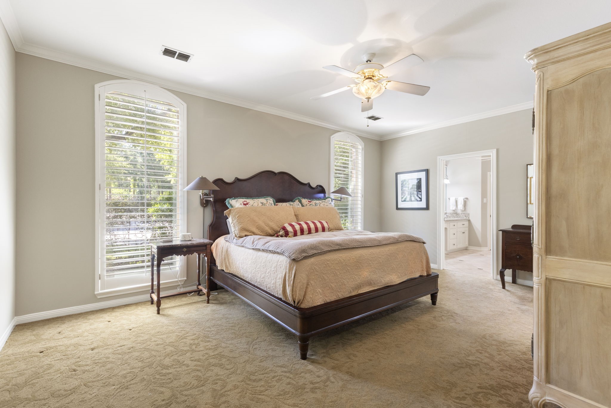 Soft natural light and a tray ceiling give the primary bedroom a restful atmosphere with room to comfortably unwind.