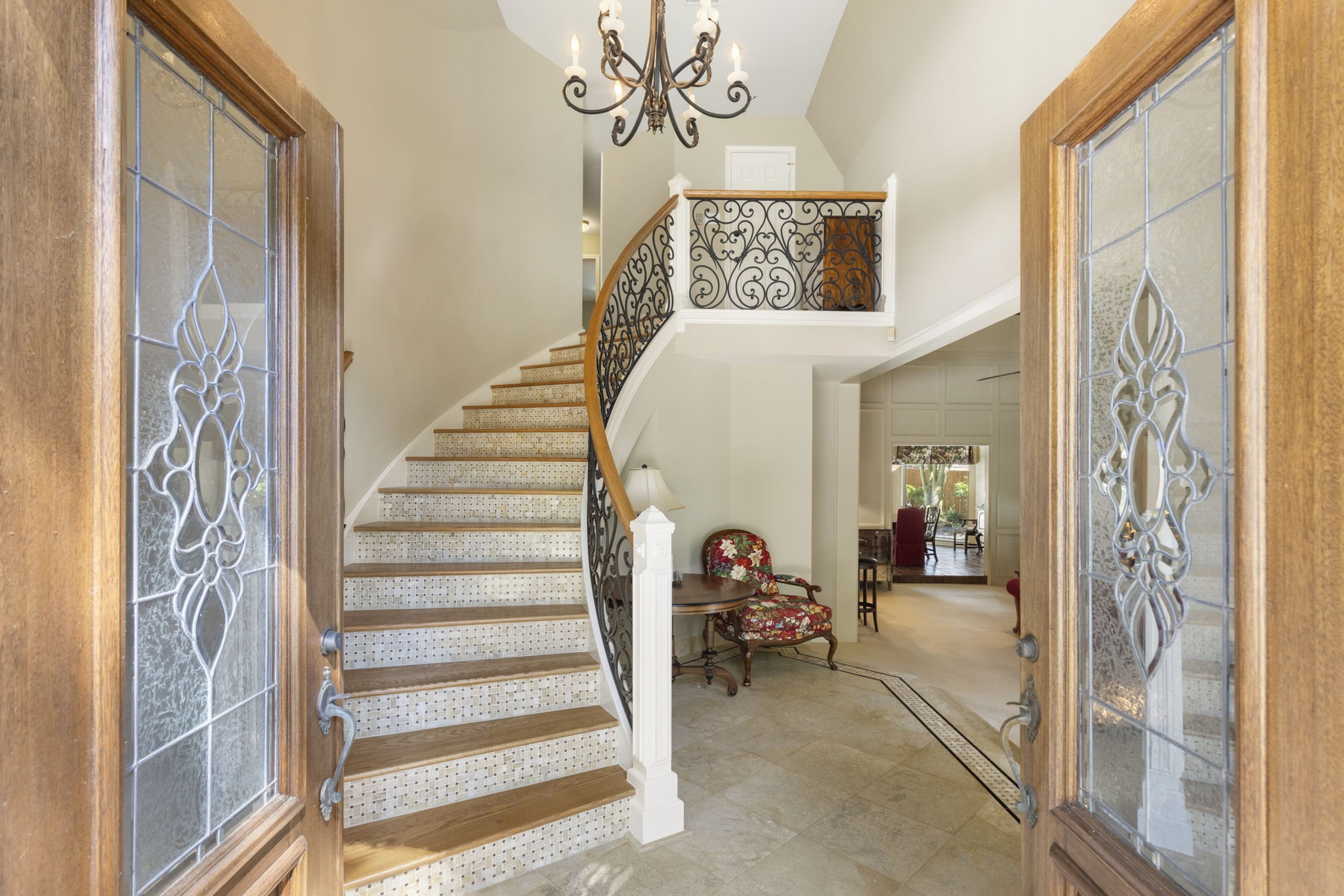 Decorative glass entry doors reveal a sweeping staircase and soaring foyer that set an elegant tone from the moment you arrive.