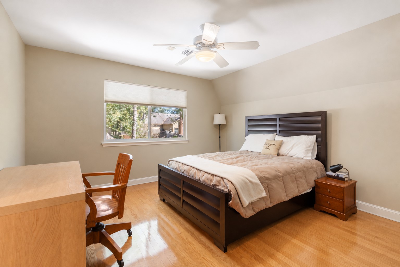 Natural light, wood flooring, and comfortable proportions make this secondary bedroom an inviting personal retreat.