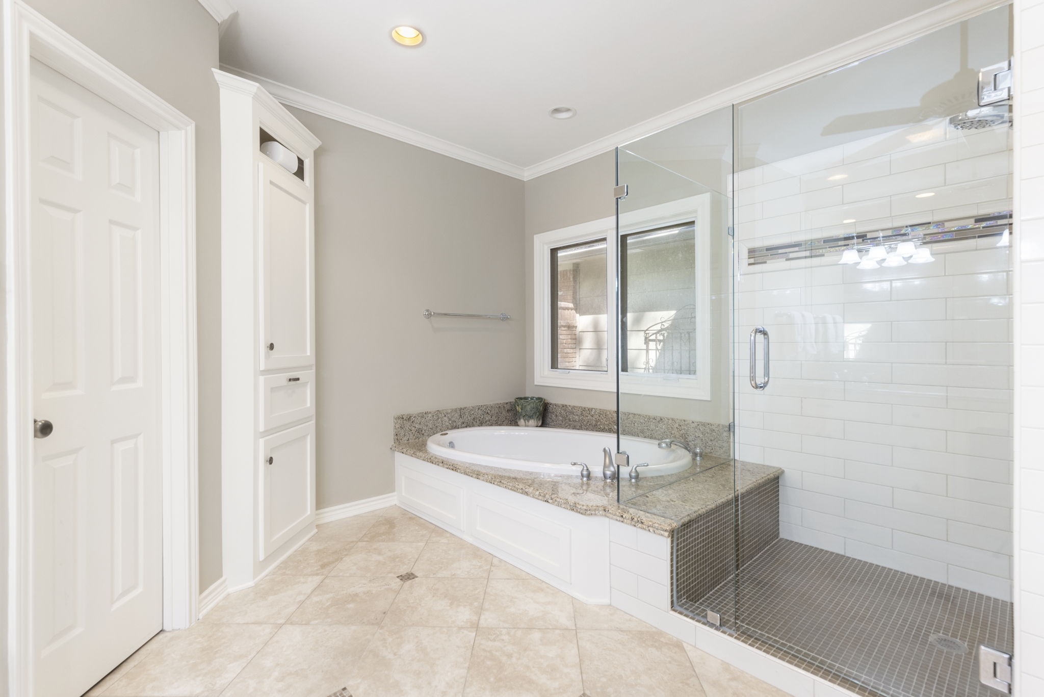 Enjoy a relaxing soak or a refreshing shower in a primary bath featuring a separate tub and glass enclosed shower.