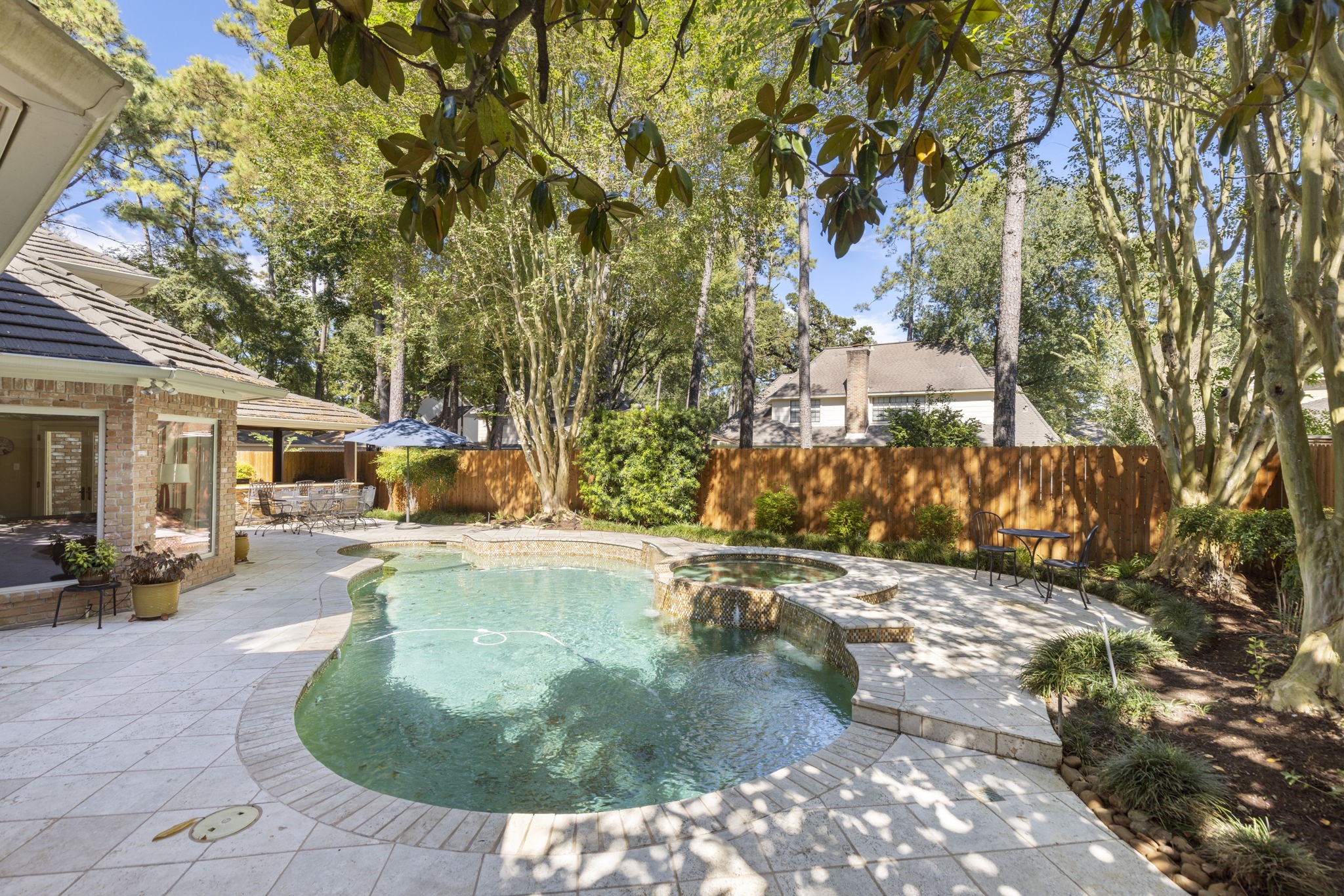 Curving pool edges, generous decking, and mature landscaping create a backyard escape just steps from the house.
