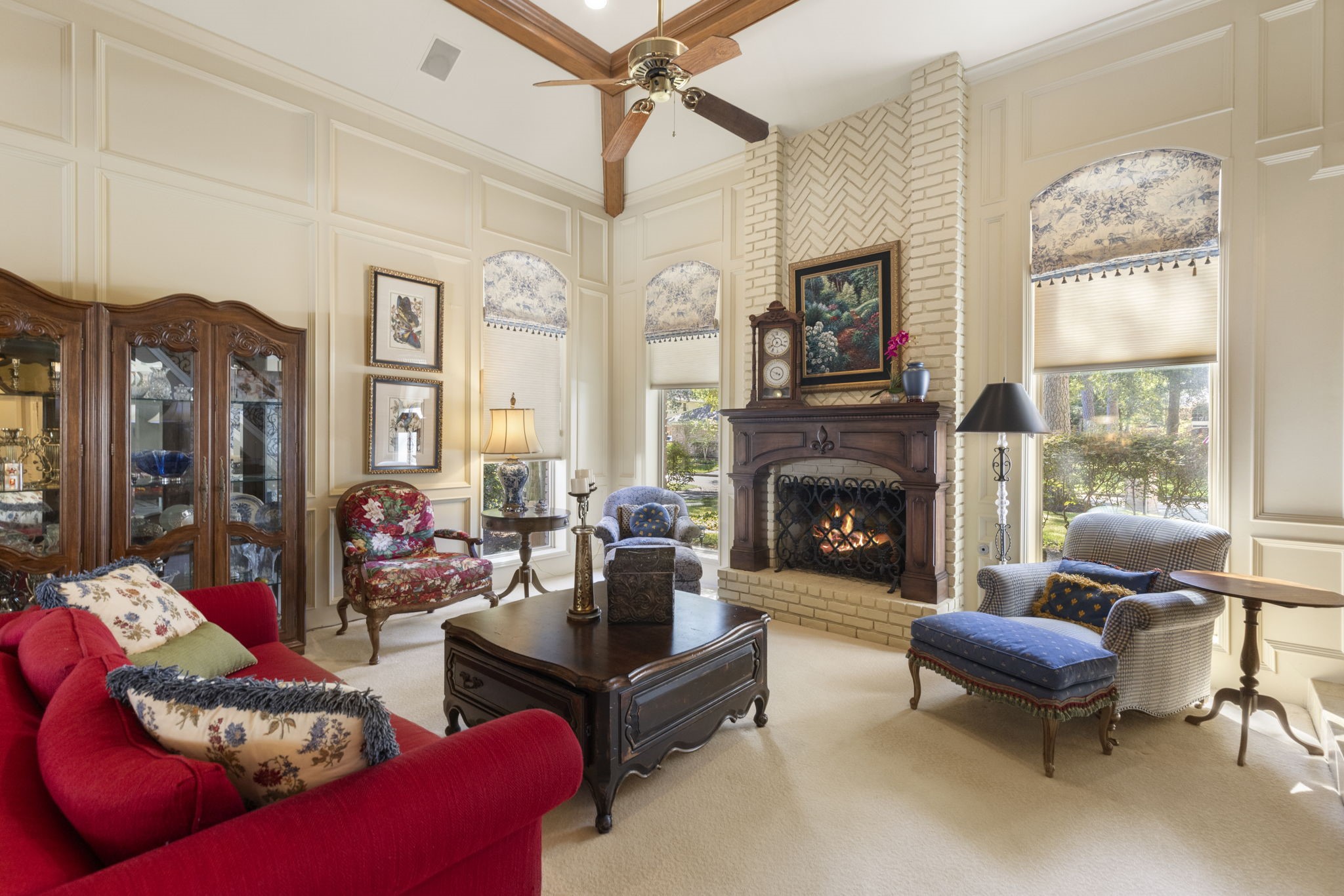 Exposed ceiling beams and tall arched windows lend warmth and dimension to the beautifully proportioned living room.