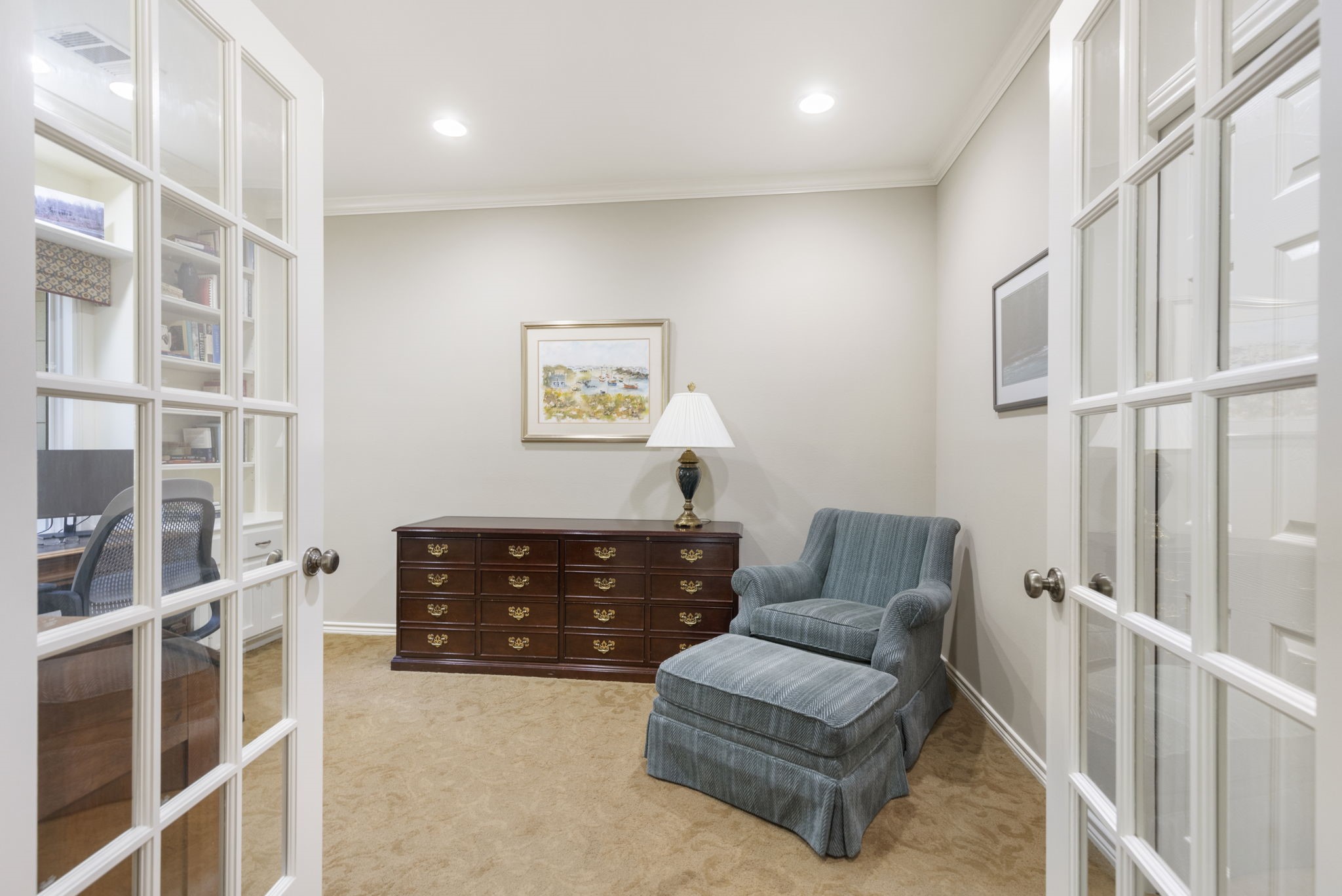 Glass French doors connect the primary bedroom with an adjoining private flex space suited to reading, work, or quiet retreat.