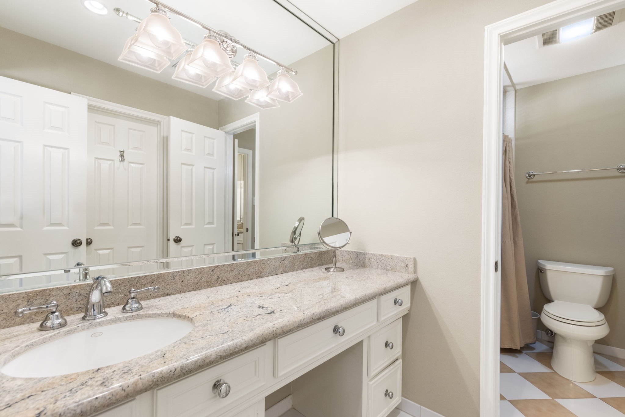 A generous vanity and a separate toilet and bathing area add practical convenience to this secondary bathroom.